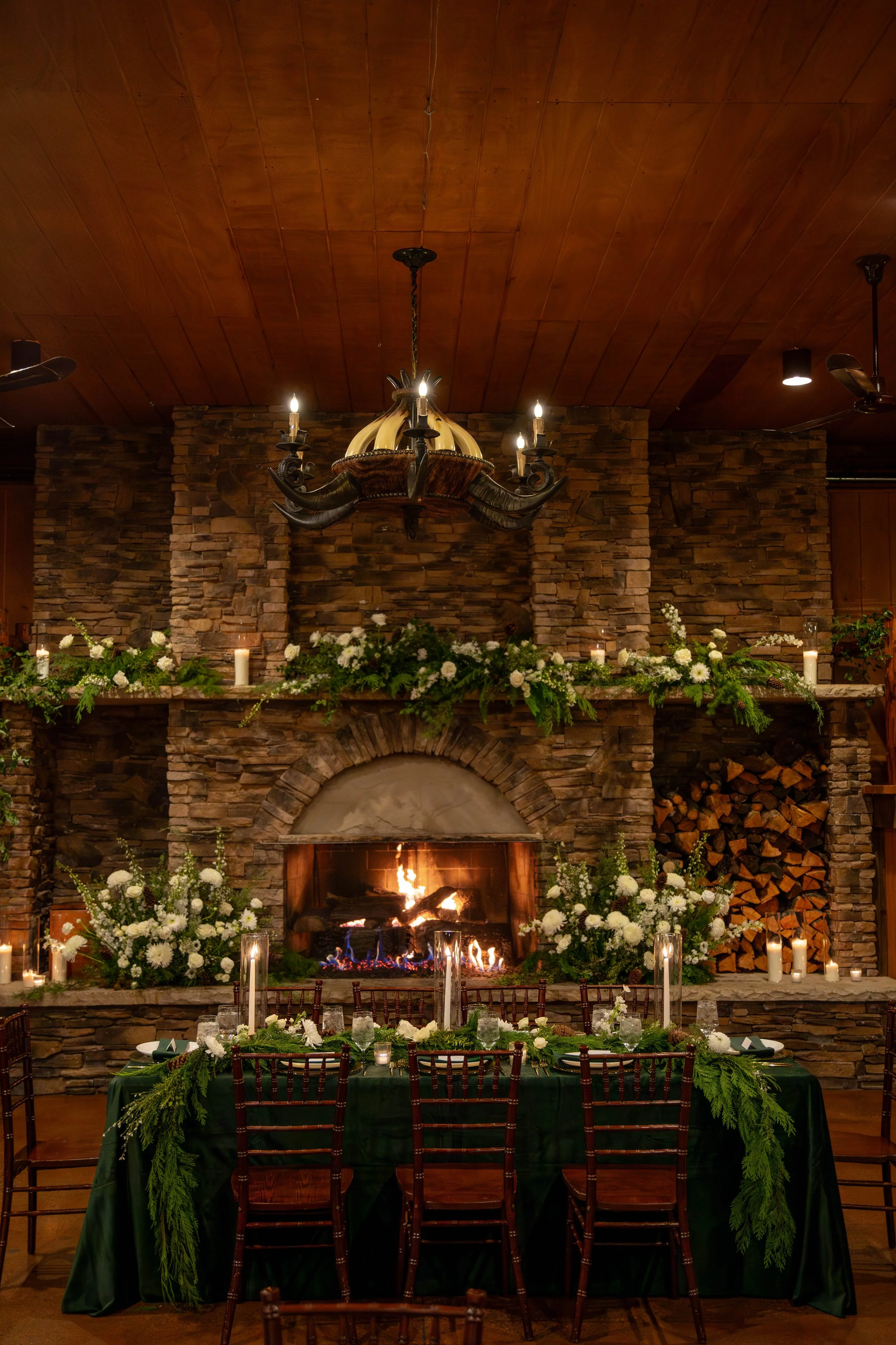 Winter wedding with greens and white flowers for the head table. Larkspur, Co