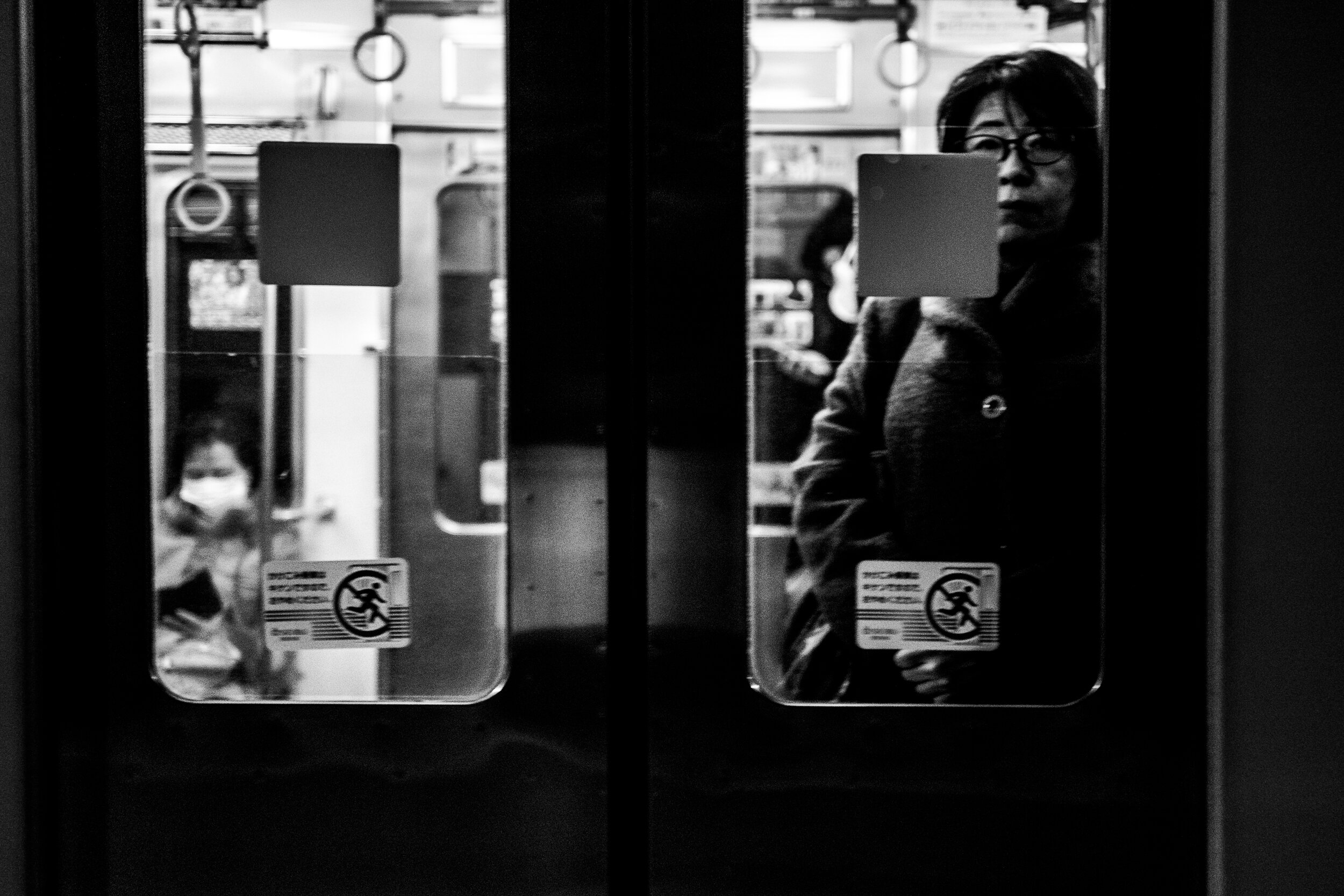 Dona mirant a l'exterior des del metro, en blanc i negre.