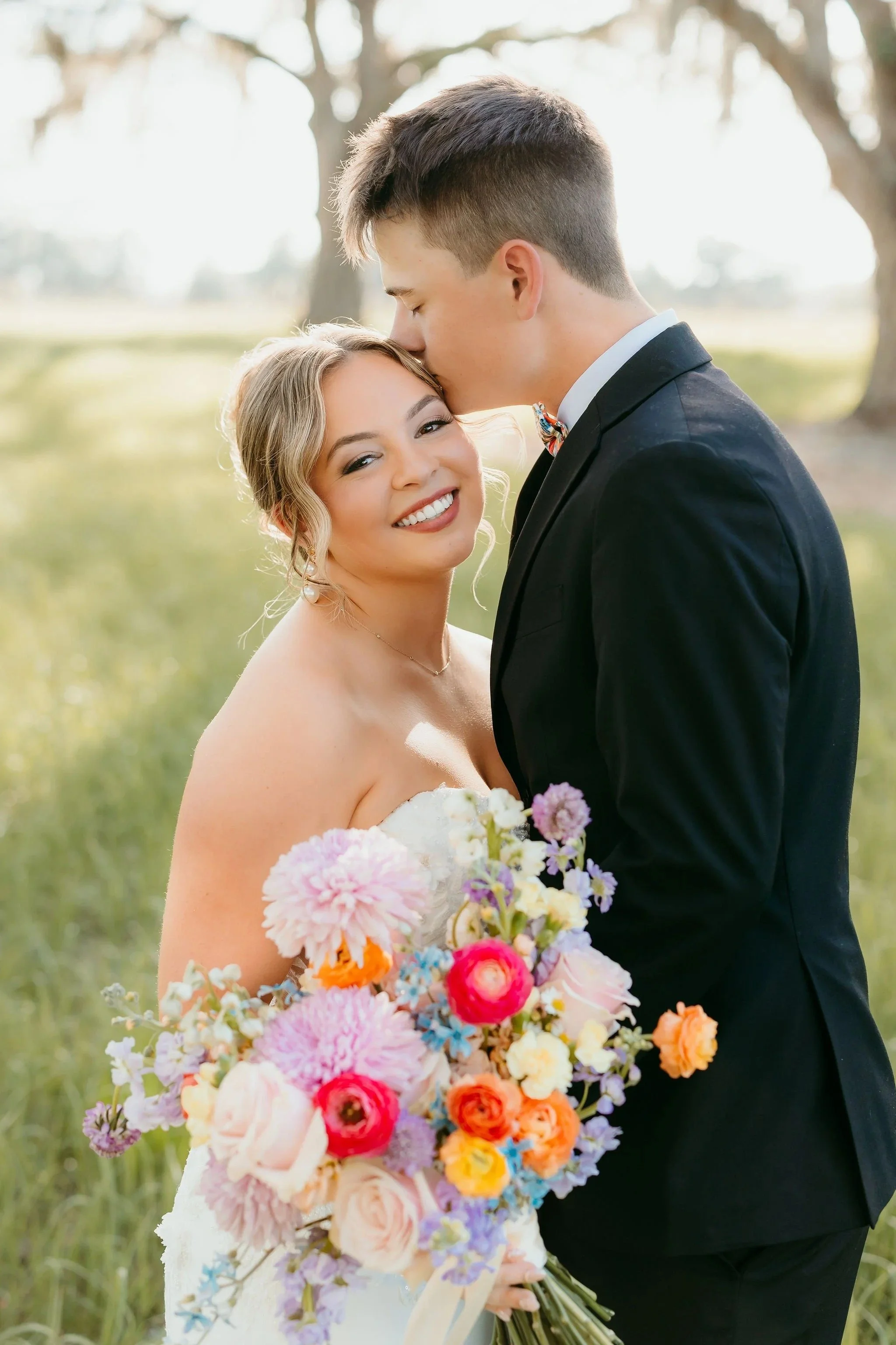 Orlando bride smiling and holding a bright and colorful wedding bouquet