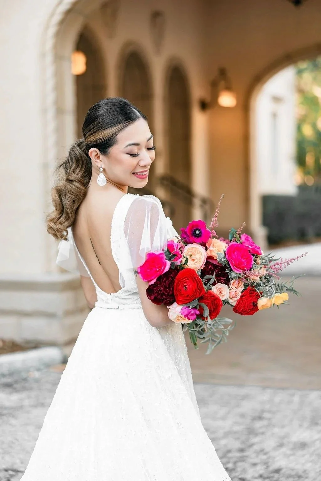 bride holding a vibrant pink and red wedding bouquet by JF Events & Flowers, an Orlando wedding florist and day-of coordinator