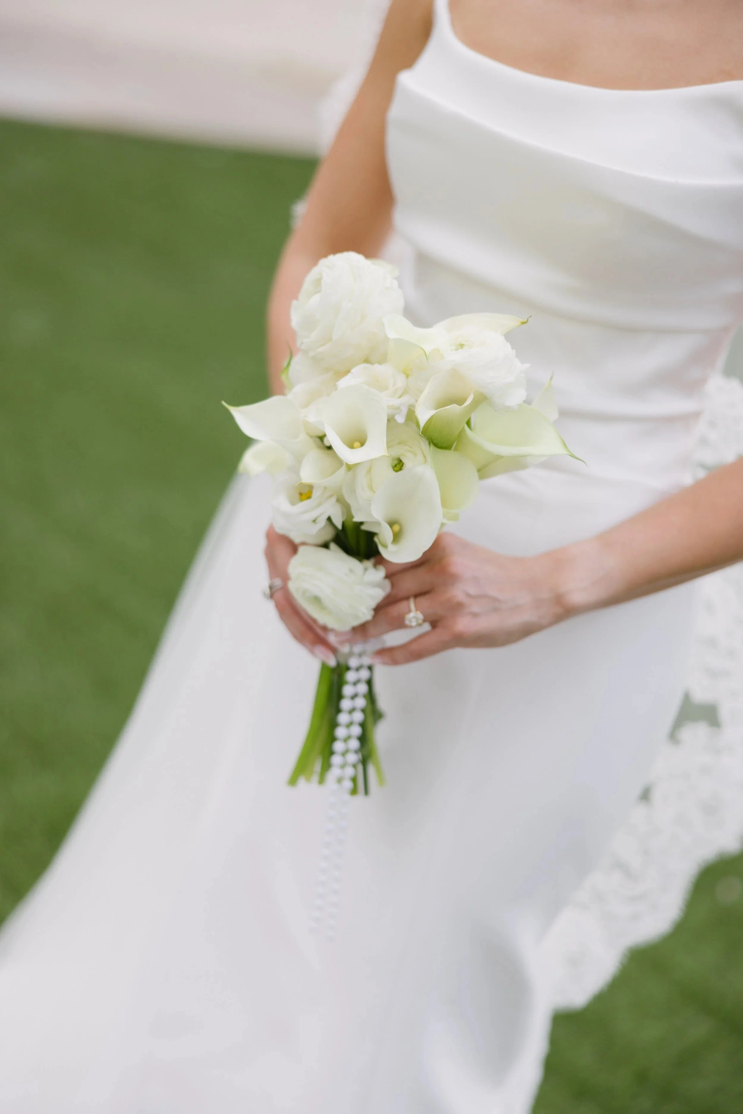 bride holding a simple and minimalistic white bridal bouquet with calla lillies by JF Events & Flowers, an Orlando wedding florist and day-of coordinator