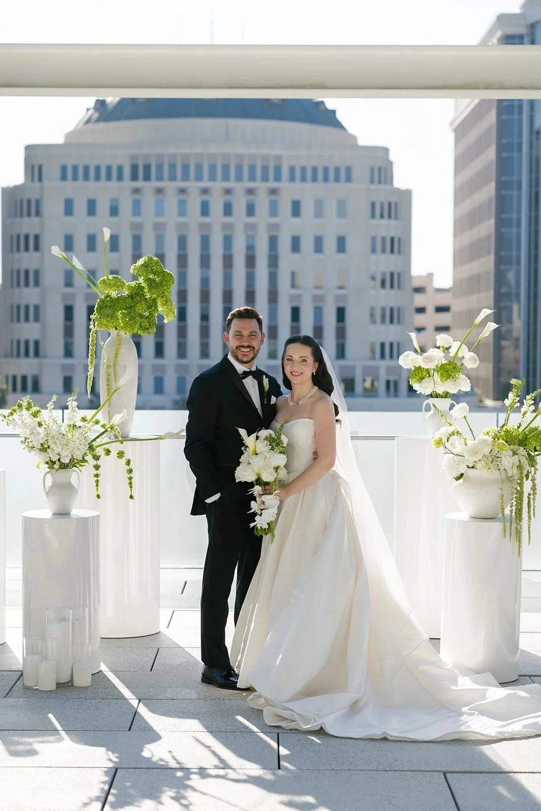 bride and groom on a Florida rooftop surrounded by modern, minimal white and greenery floral arrangements by JF Events & Flowers, an Orlando wedding florist and day-of coordinator