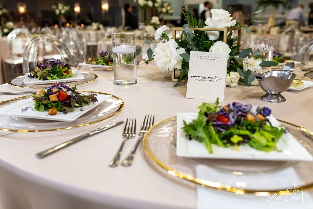 Elegant table setting with salads, glass of water, and floral centerpiece