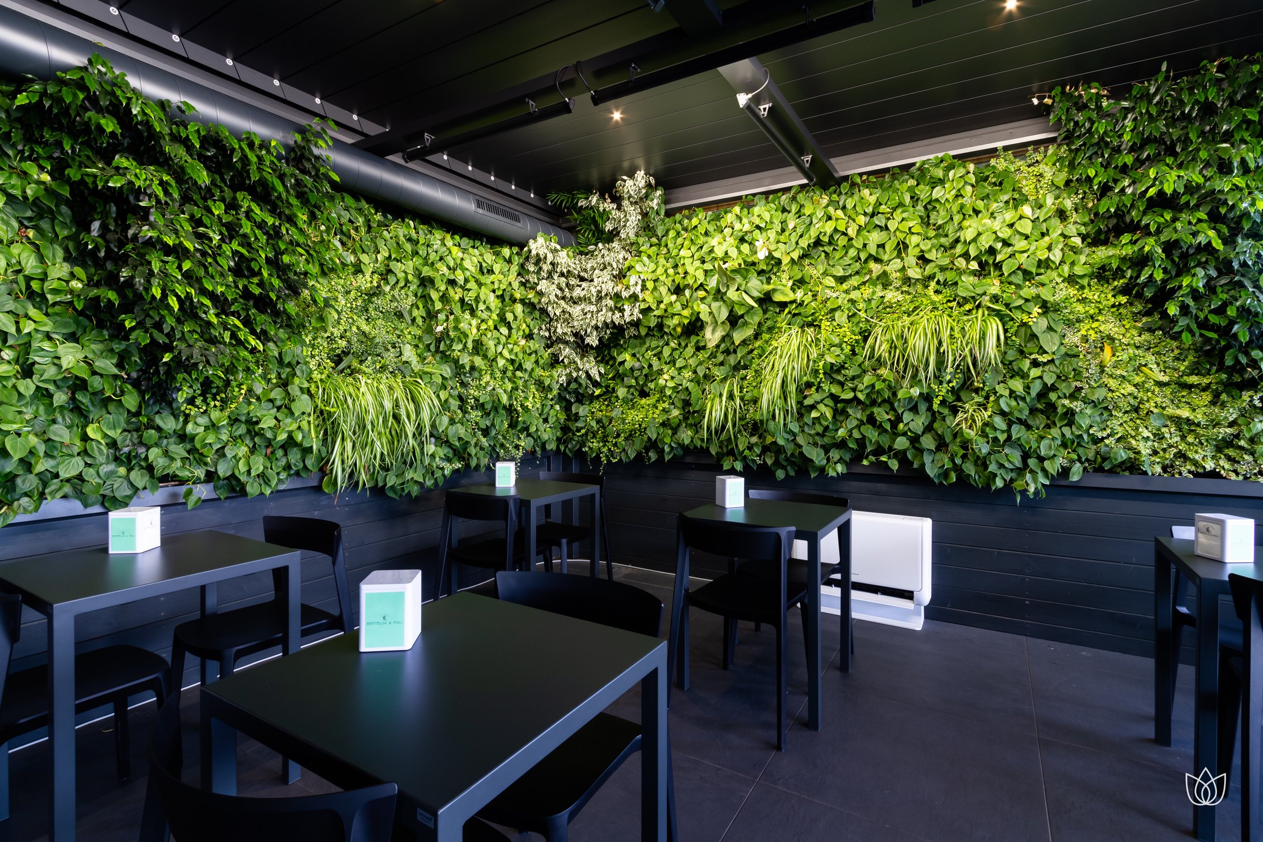 Interior of a restaurant with green walls filled with plants