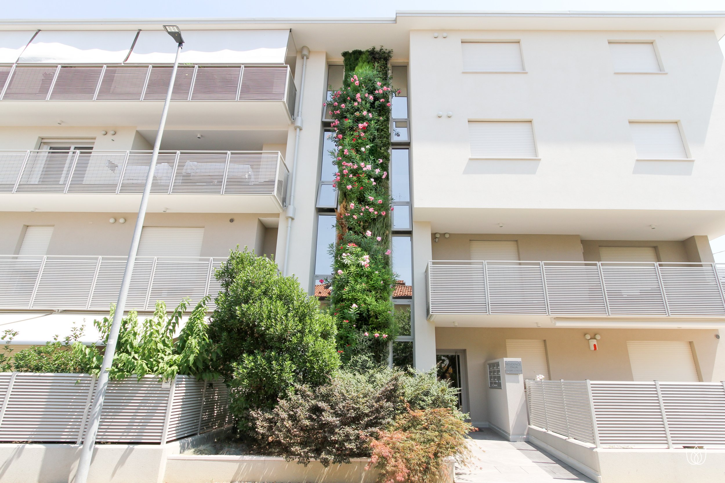 Modern apartment with balconies and a vertical wall of flowering plants