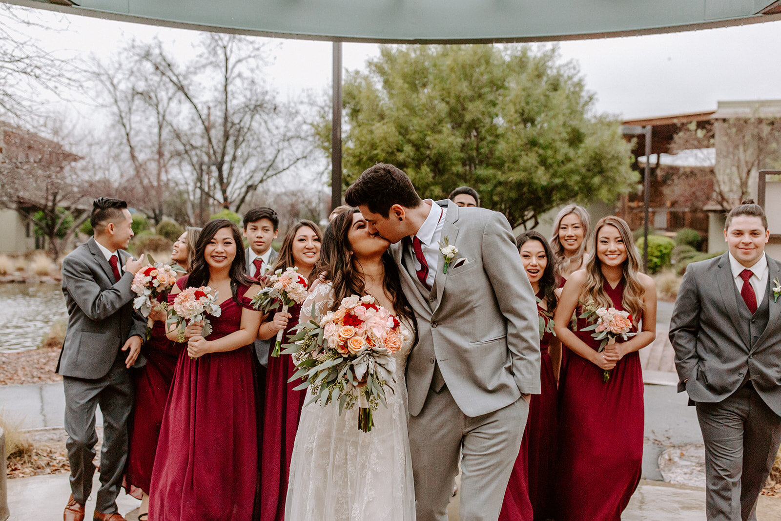 Bride+and+groom+kissing+with+wedding+party.jpg