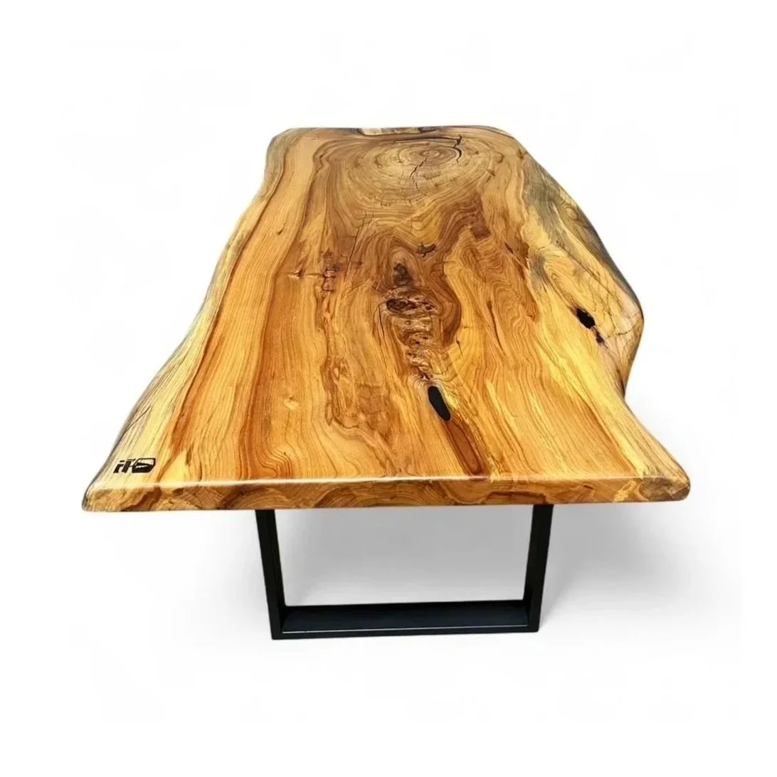 A wooden table with a natural, irregular edge and visible wood grain, supported by black metal legs.