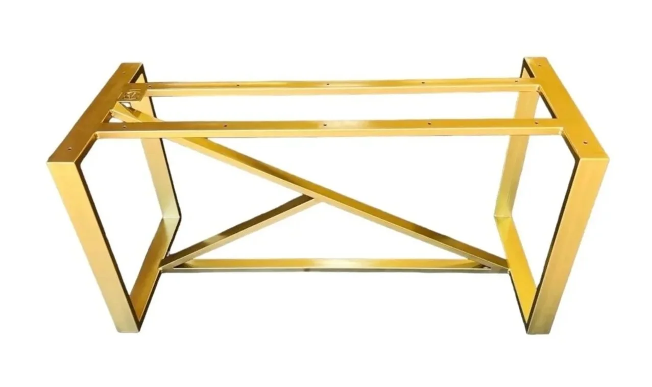 Gold-colored metallic furniture frame, possibly a table or bench, with no surface on top, isolated on white background.