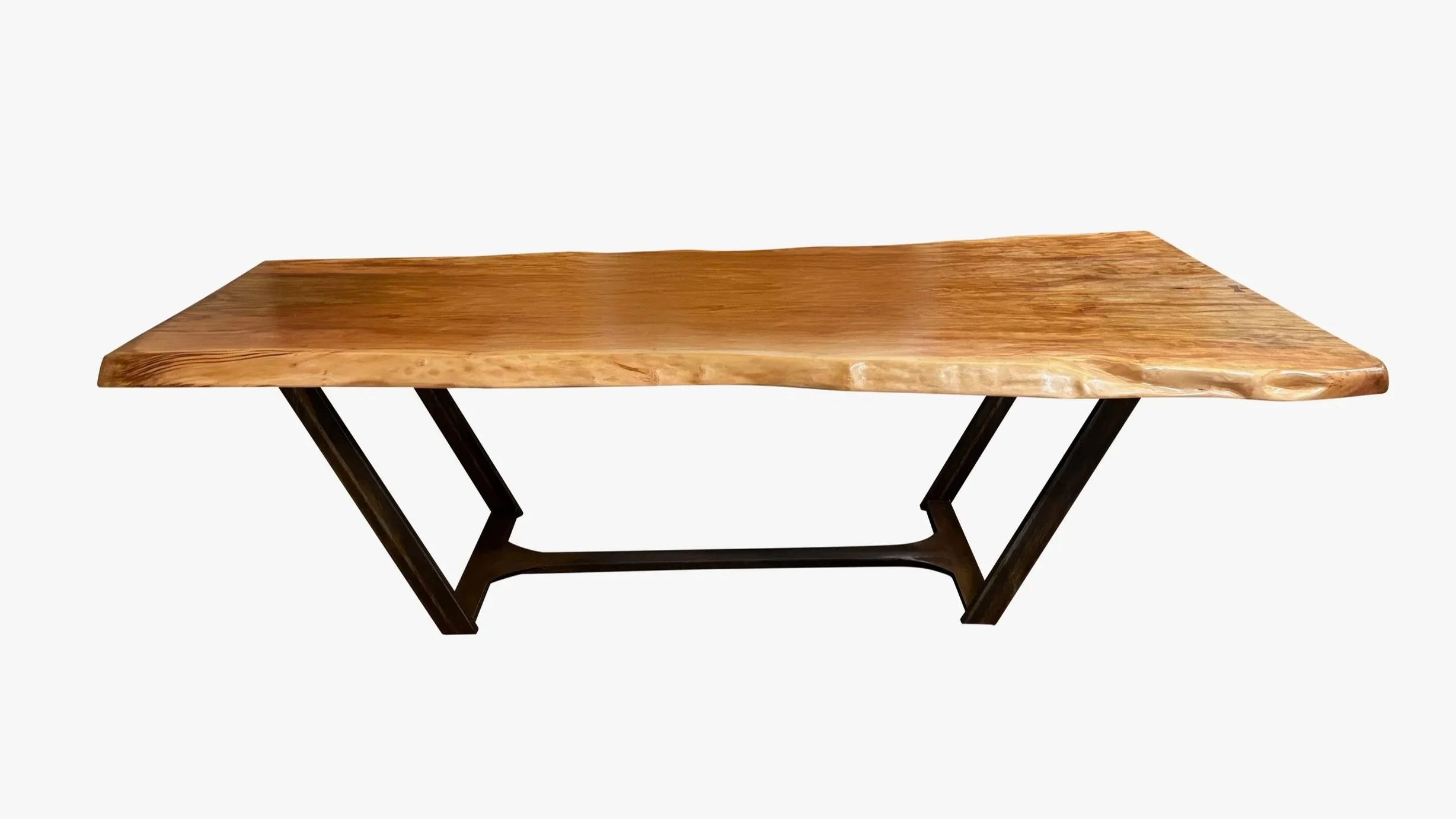 Wooden table with a natural, live edge, supported by black metal V-shaped legs, on a white background.