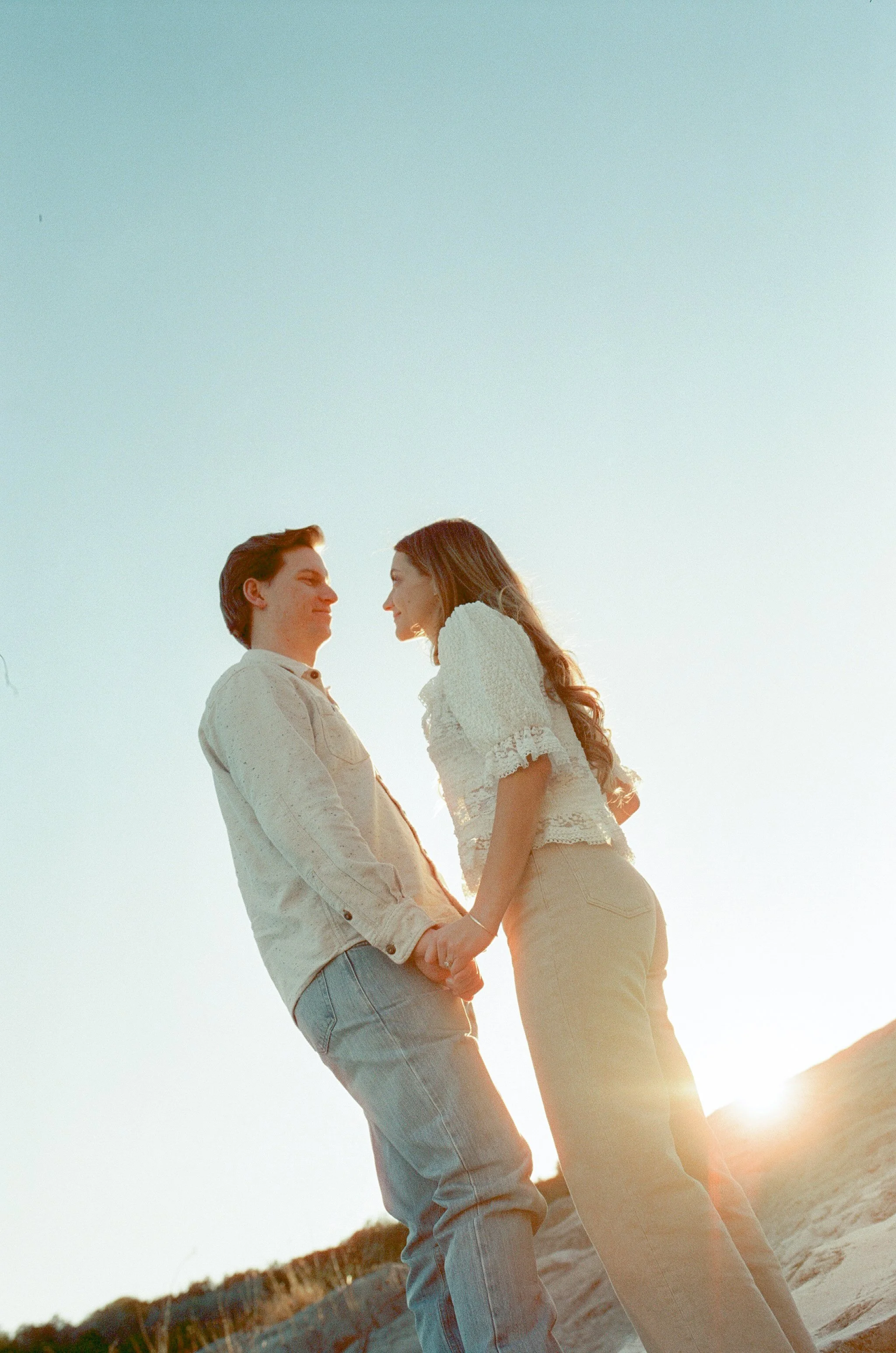 Engagement Session Couple holding hands at sunset Photographed on Film at Pedernales Falls State Park in Johnson City, Texas.