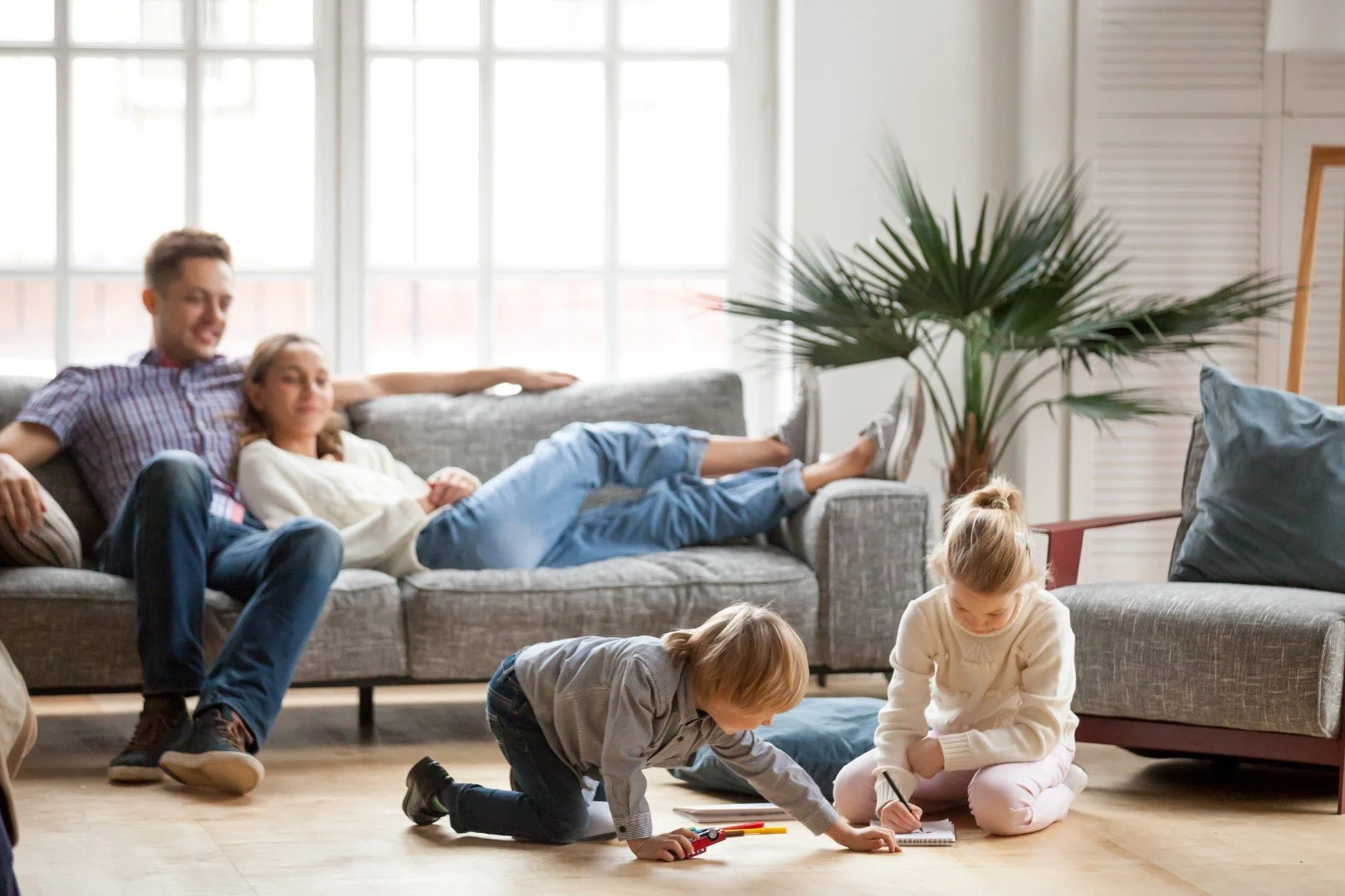 Family sitting in new rental home in Calgary. 