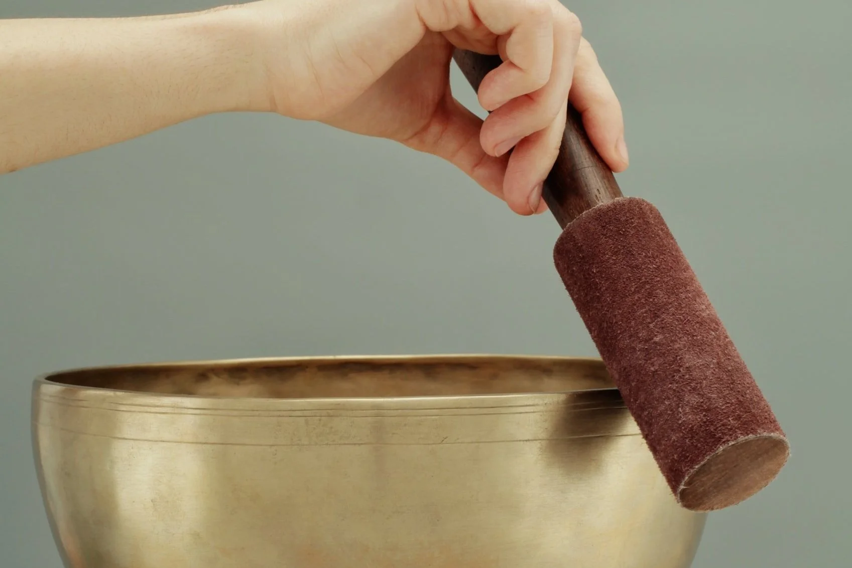 a practitioner at Very Well KC playing a himalayan sound bowl