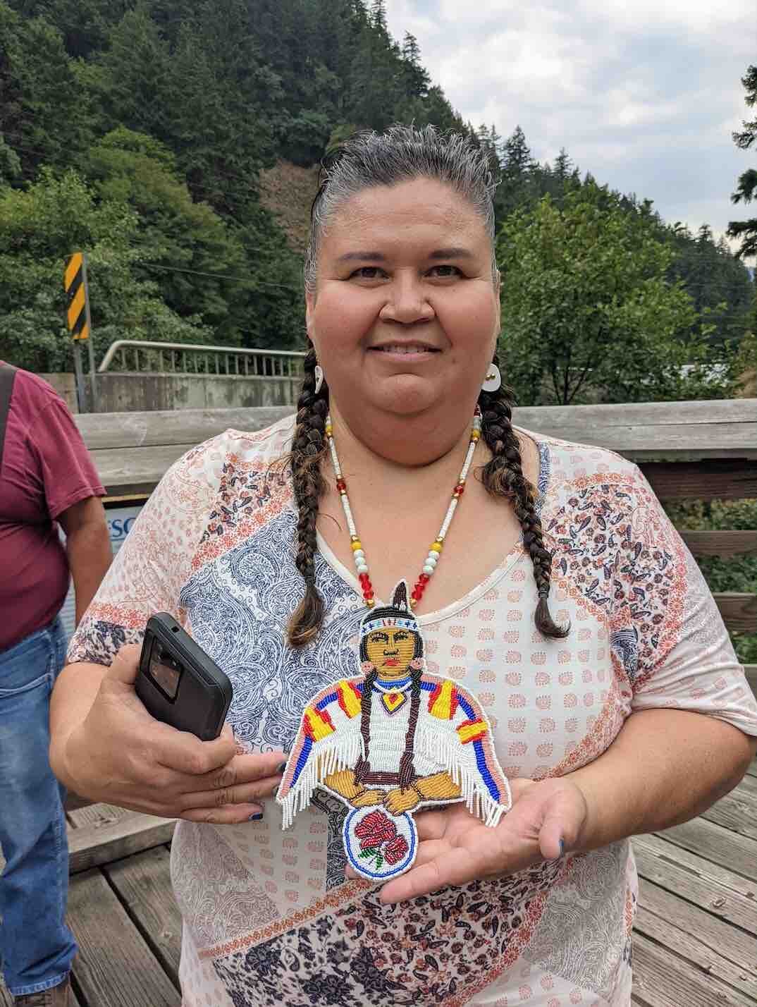 Donella Miller, Yakama Nation Fisheries Program Manager, shared the story of the jewelery she wore to the vigil, saying it was a handmade portrait of her grandmother. 