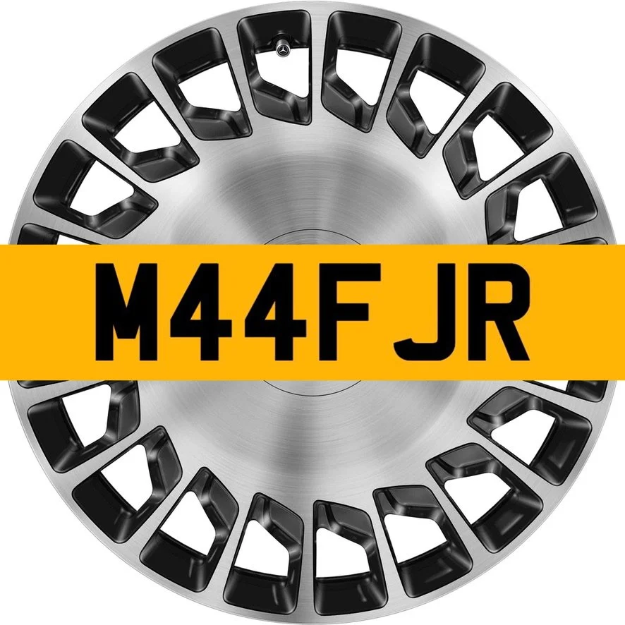 A Mercedes-Benz Maybach wheel rim with a yellow UK number plate displaying the text 'M44FJR'