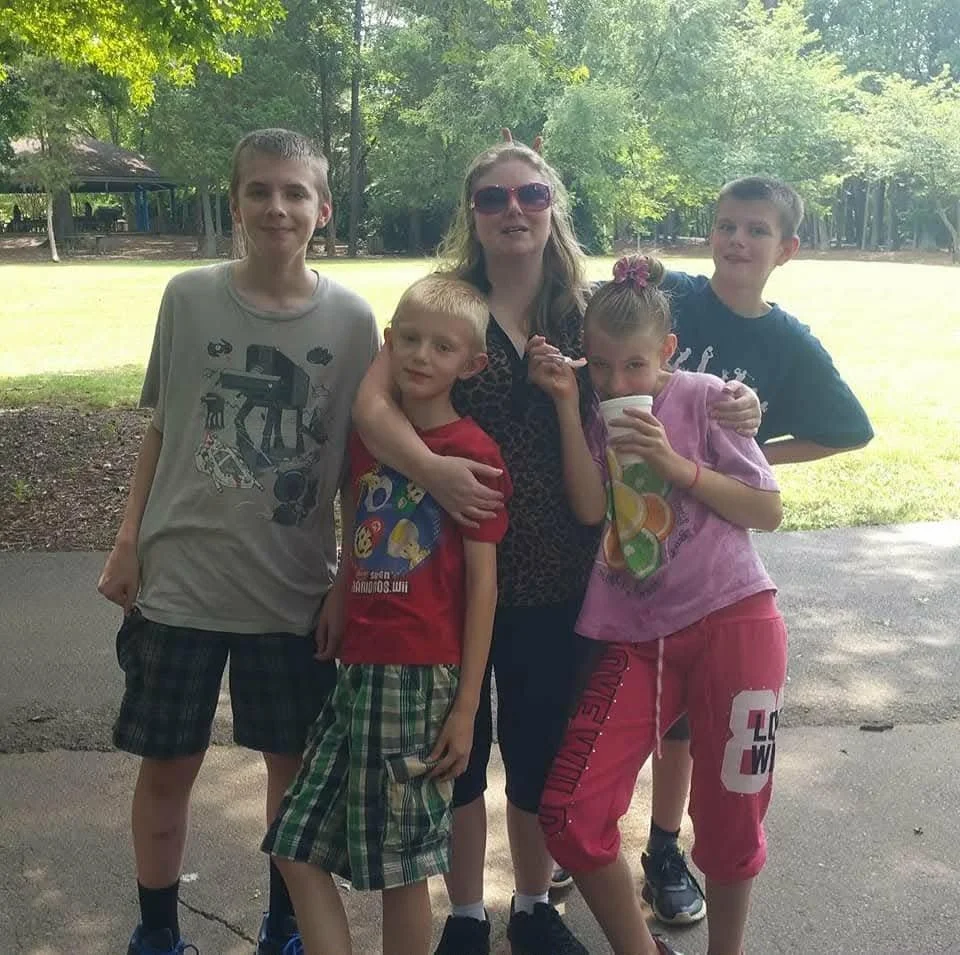 All of the kids with their mom at the park 