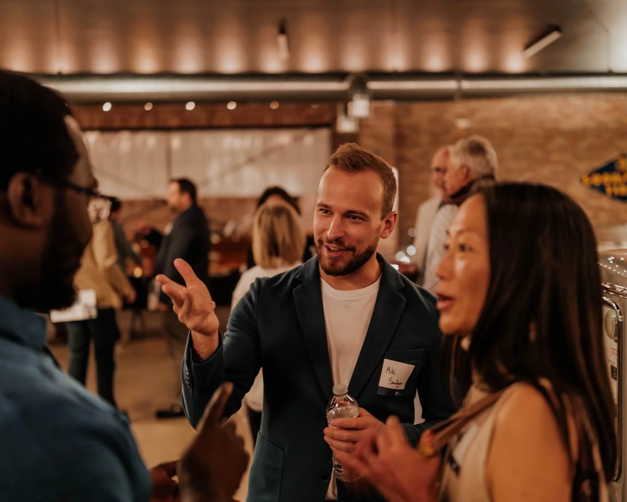 Networking attendees engage in conversation during an AsOne community event in Denver, Colorado, fostering meaningful connections and collaboration