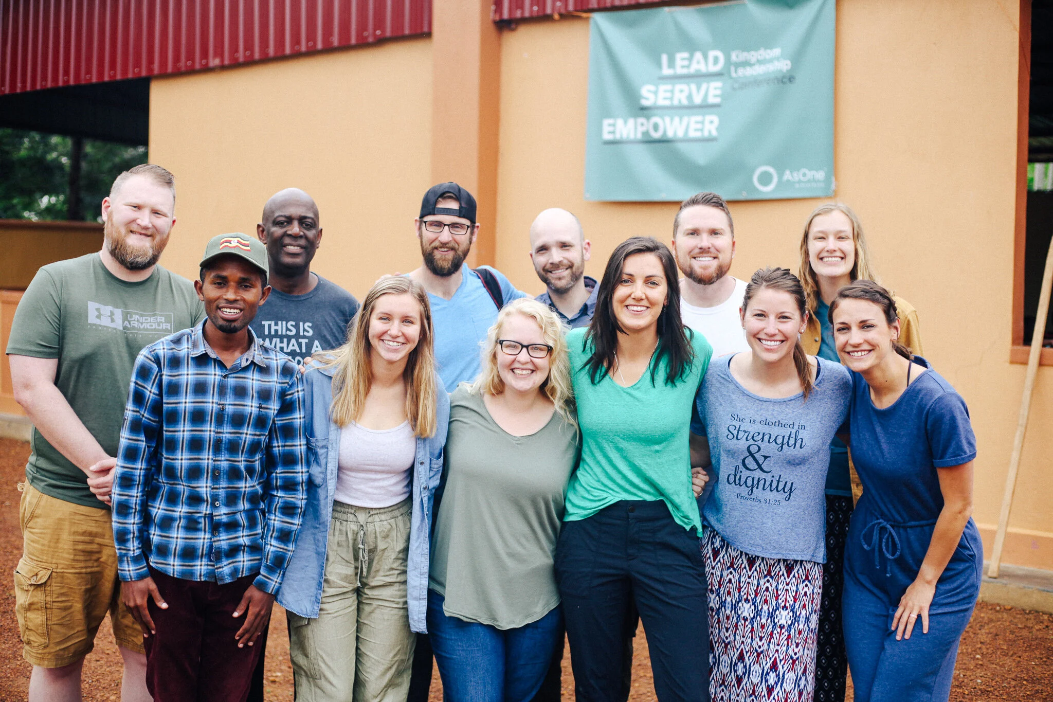 Group photo of AsOne immersion trip participants and staff standing together outside an AsOne building