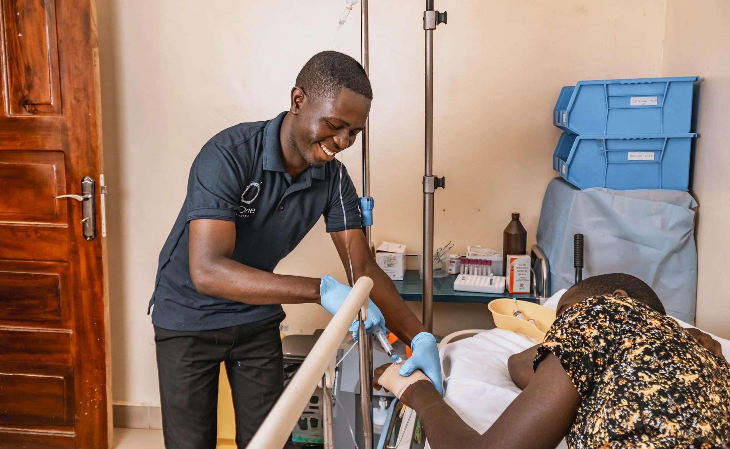 AsOne health worker administering treatment to a patient at Healing Grace Medical Center, Idudi