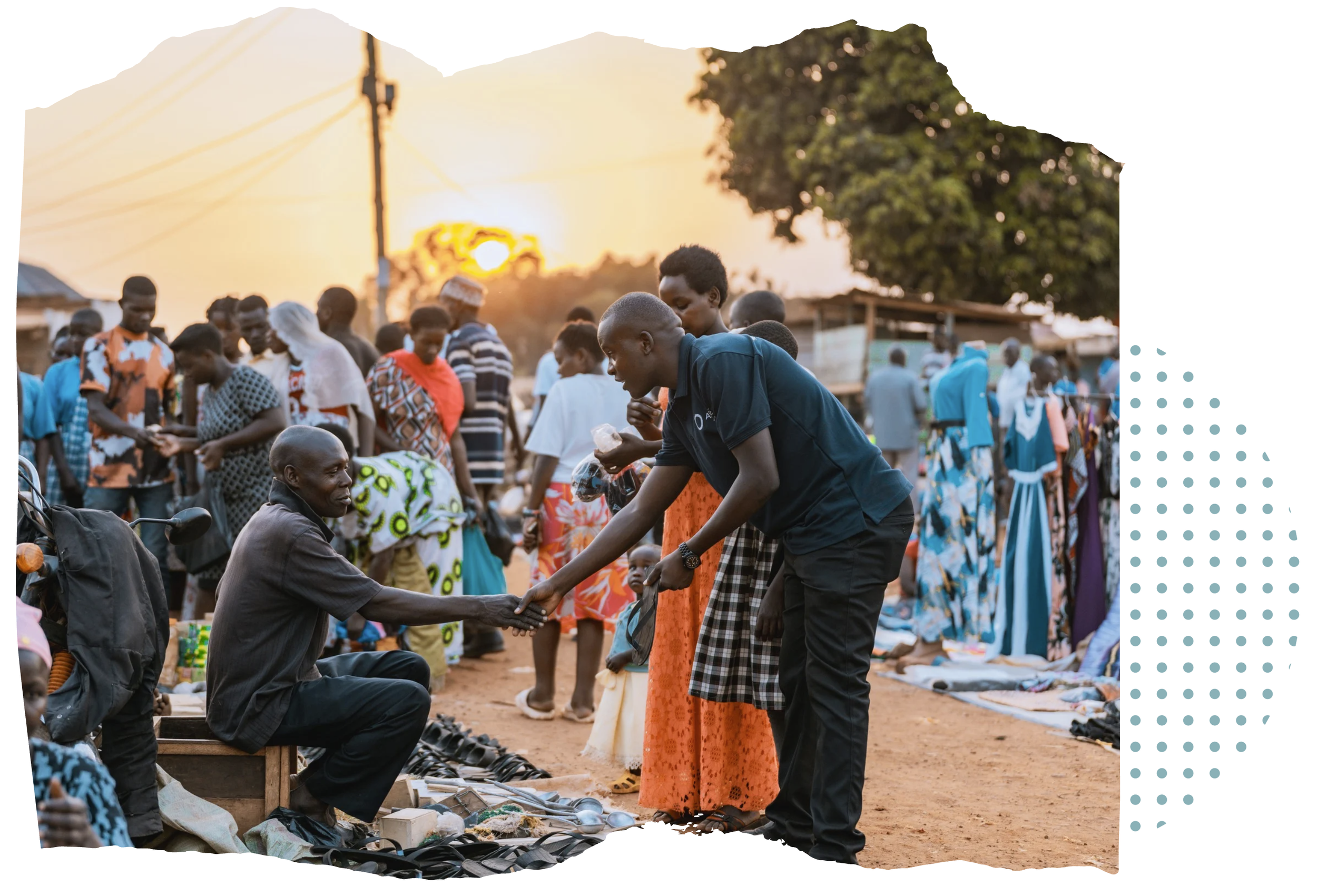 Deogracious Waisswa, AsOne community director, shaking hands with a man during community outreach at a busy market in Mayuge, Uganda