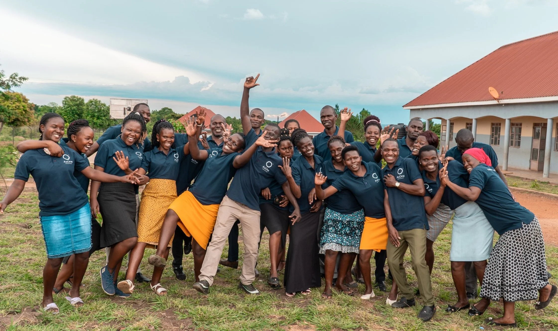 AsOne teachers celebrating together outside AsOne Nursery & Primary School in Idudi, Uganda