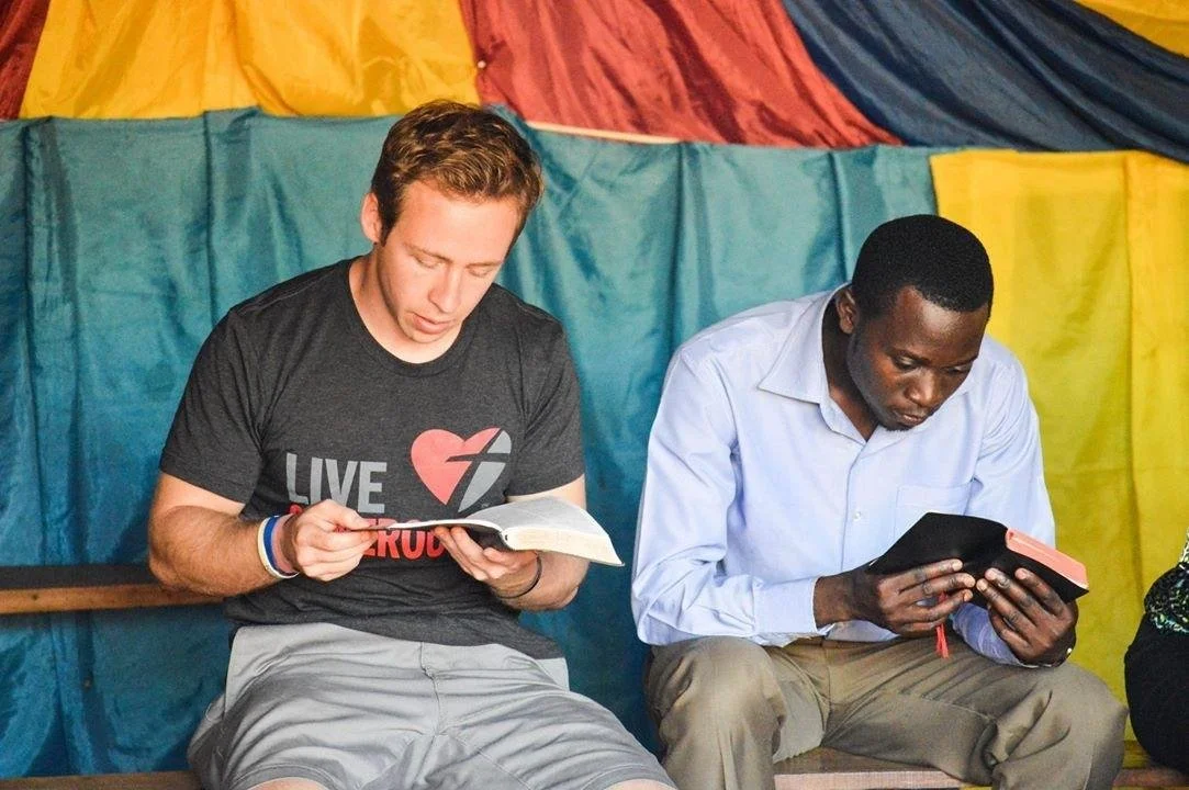 AsOne founders Andrew DeVaney and Henry Iwumbwe reading their Bibles side by side.