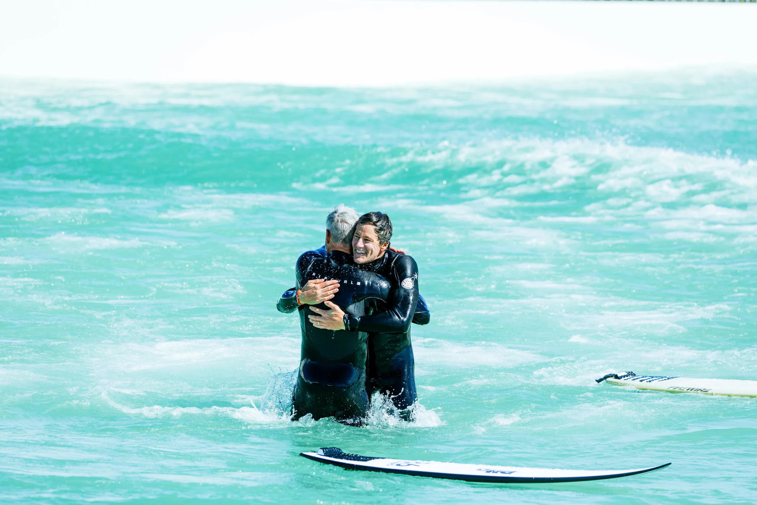 Andrew embraces good mate and early investor Adam Lamond after the first wave ridden