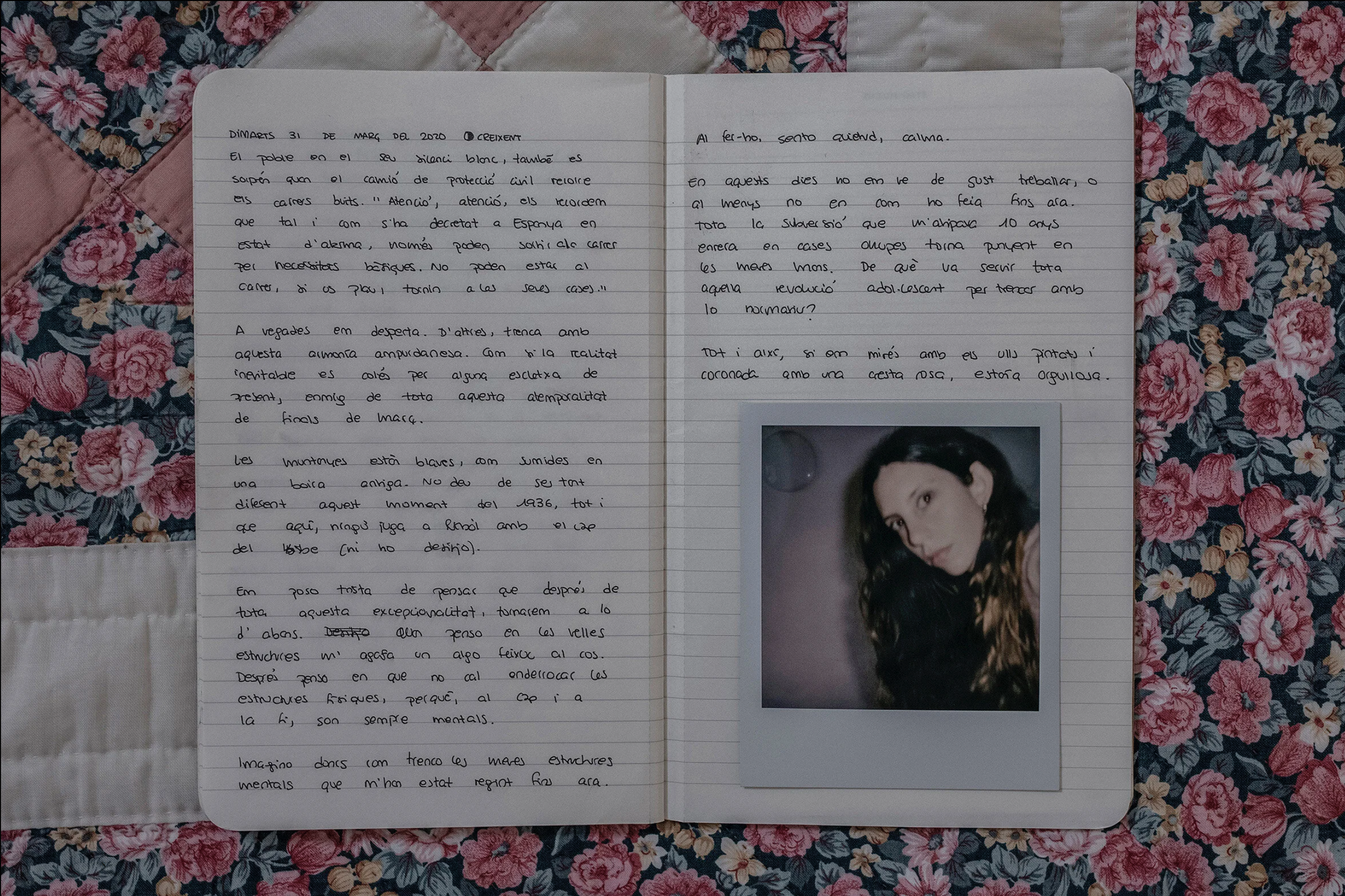 Open notebook with handwritten text and a printed photo of a woman, placed on a floral quilt with pink, blue, and green flowers.