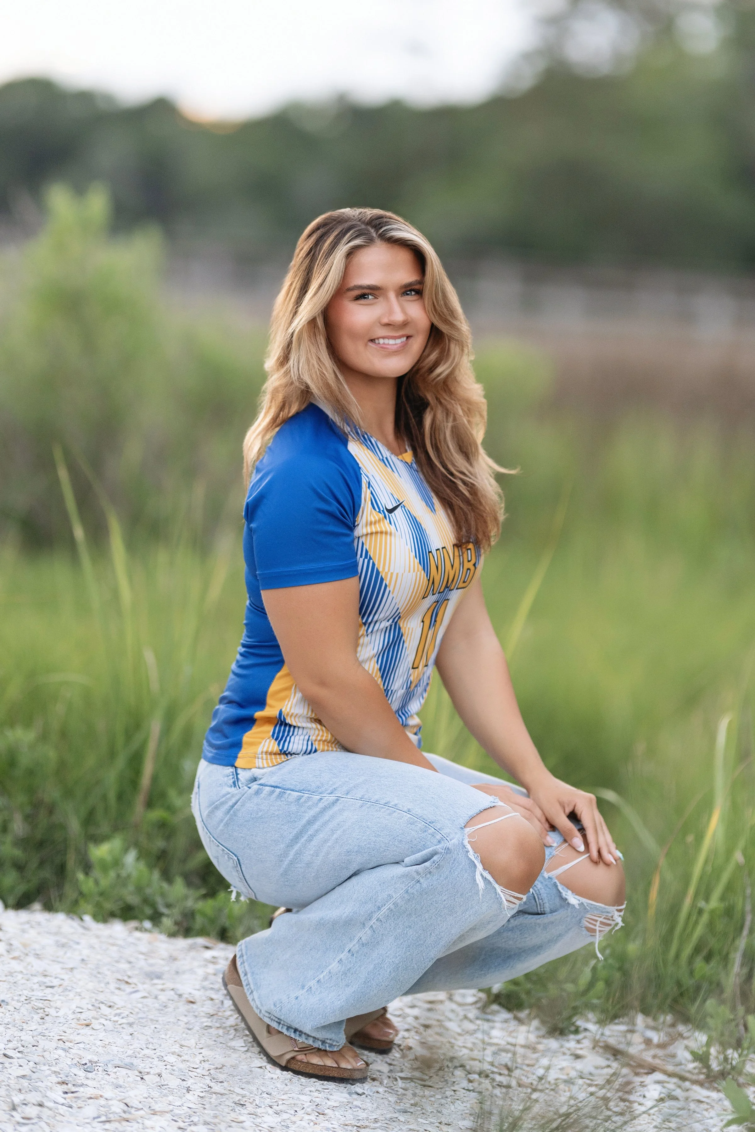 North Myrtle Beach senior photographer creating natural, light-filled outdoor portraits in a grassy field setting. 