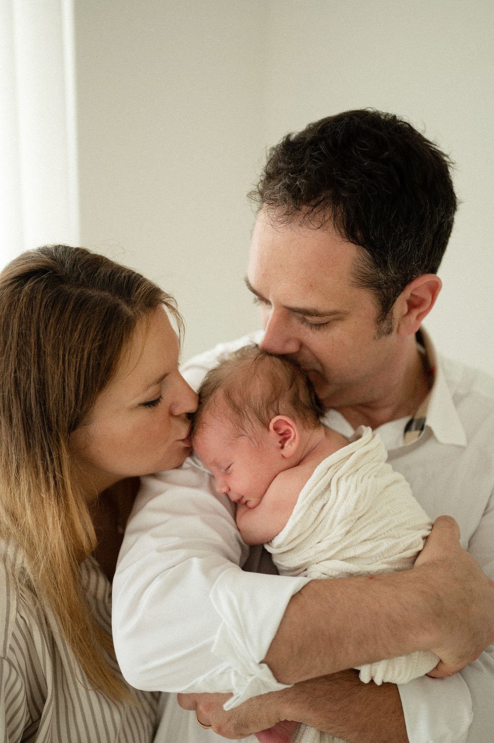 Fotografia neonato bacio da mamma e papà
