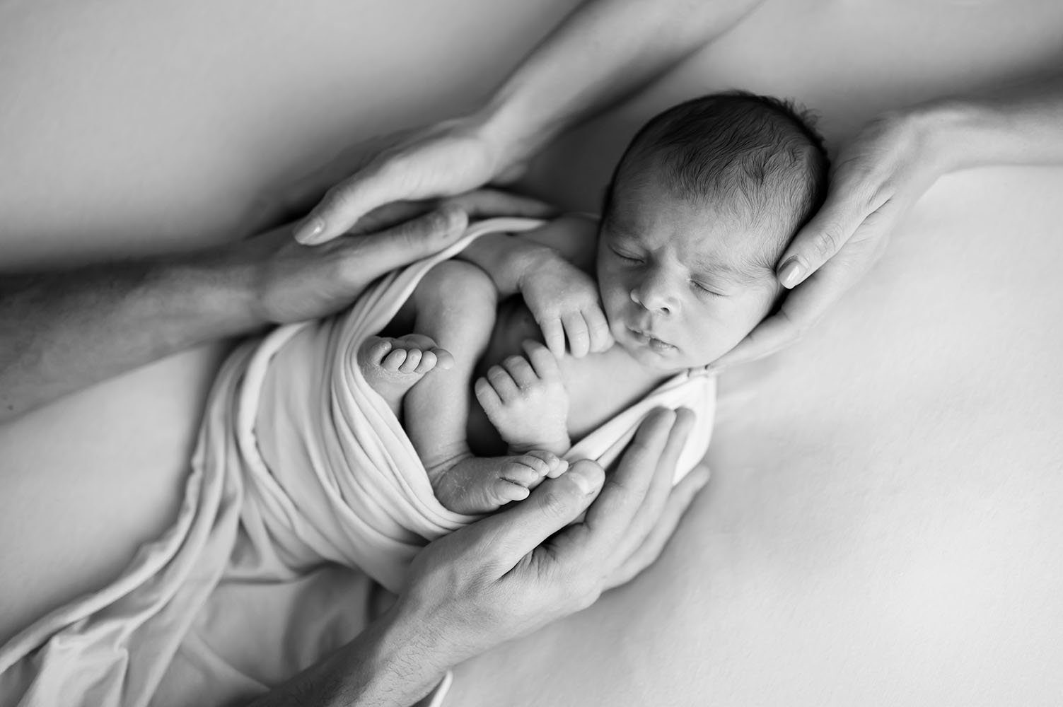 Fotografia neonato mani genitori