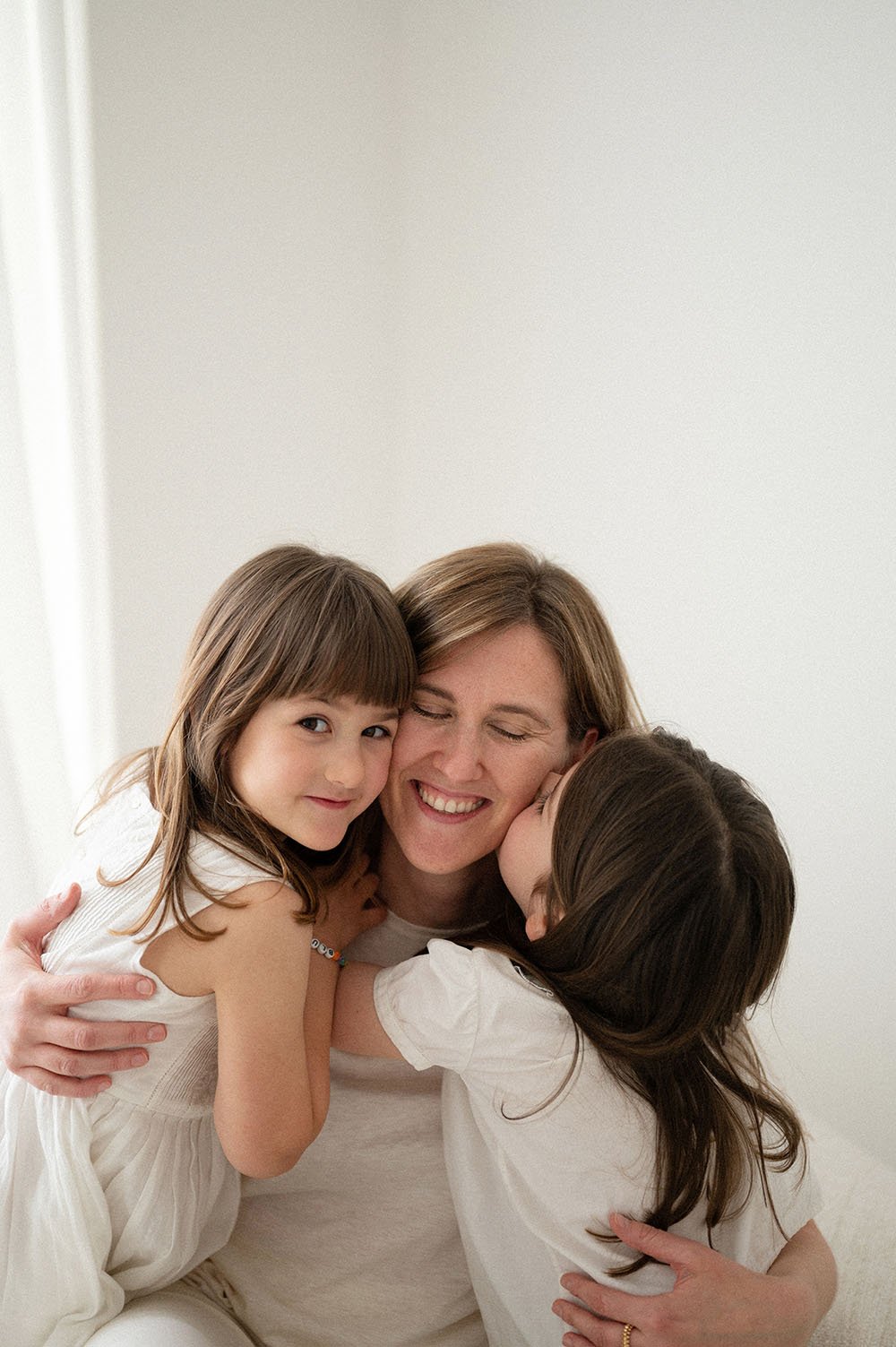 Fotografia famiglia sorelle che baciano la mamma