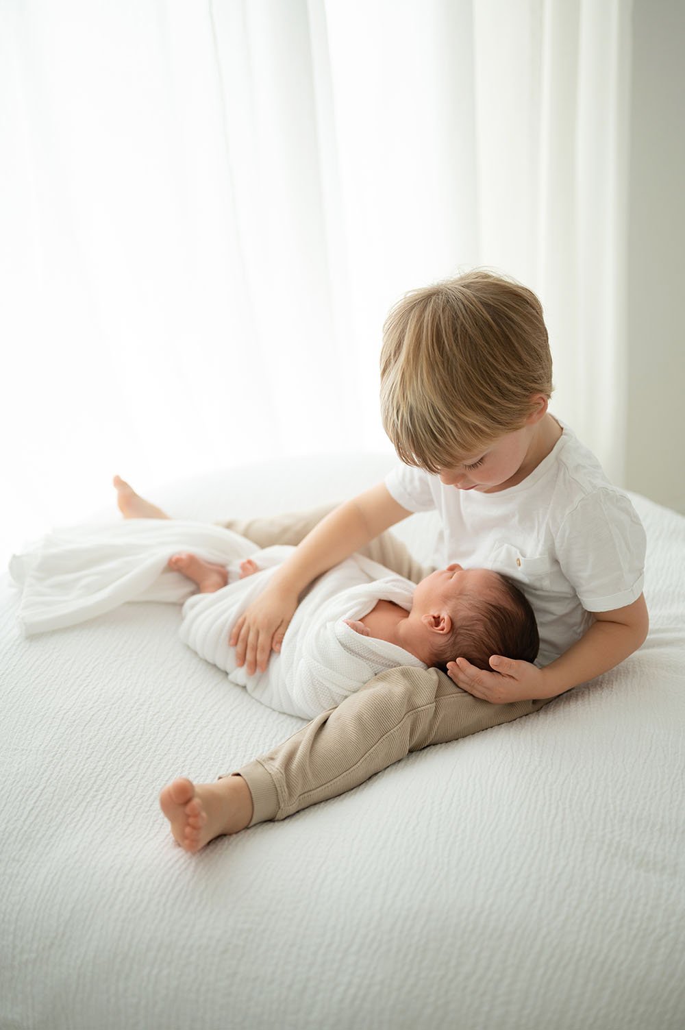 Fotografia neonato coccole con fratello