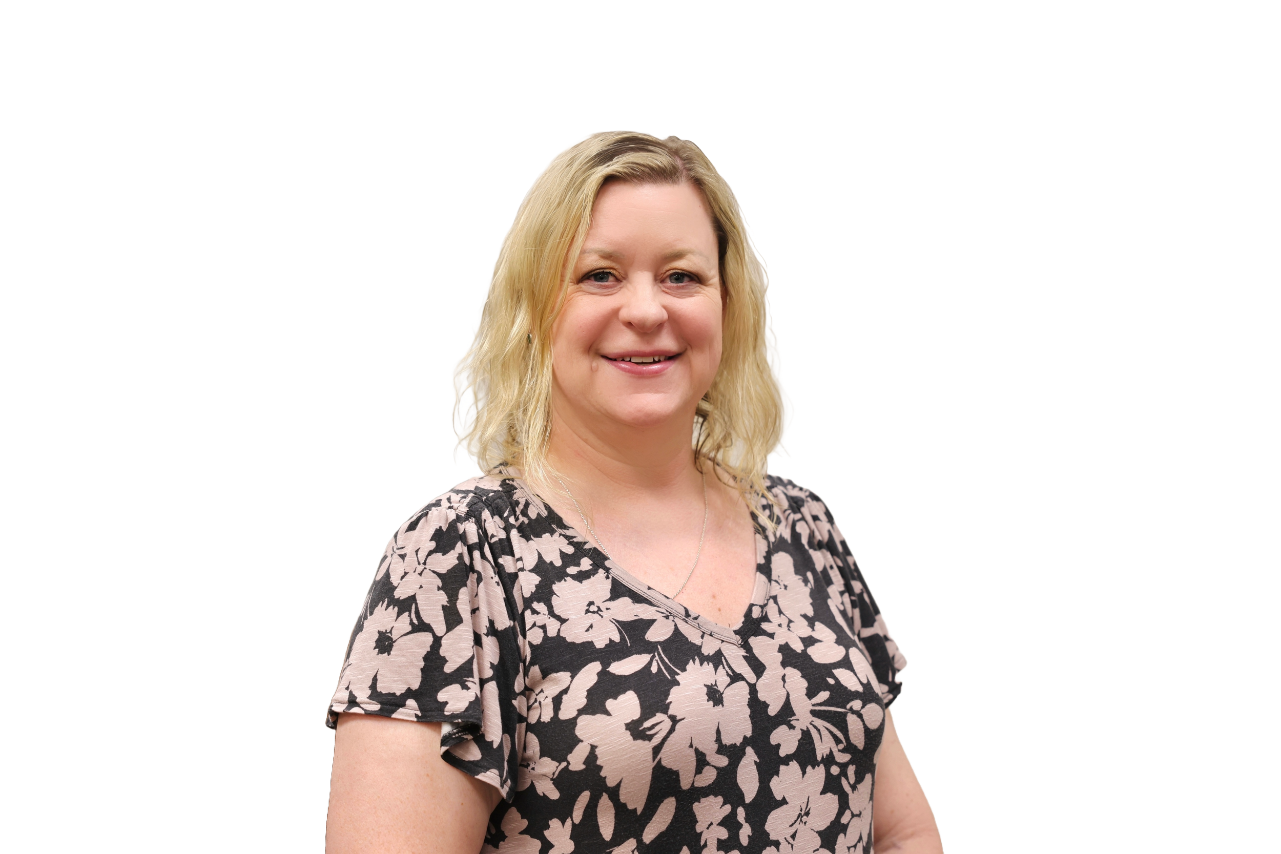 Director of Compliance and EEO, Stacey Thorgersen, smiling with wavy blonde hair in a floral top, black background.