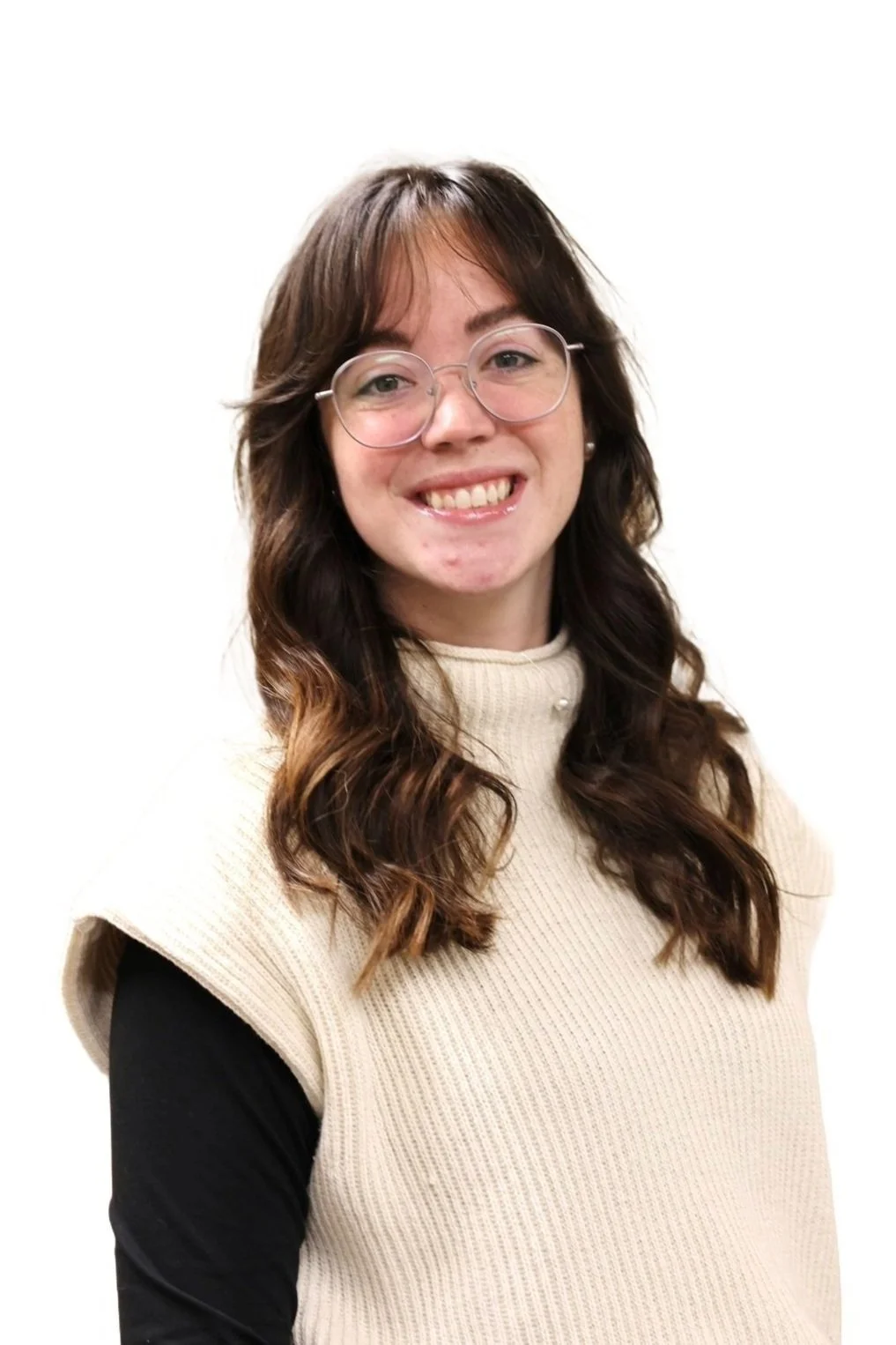 Business services coordinator, Mallory Copeland, with glasses and brown hair smiling, wearing a beige sleeveless sweater over a black long-sleeve top.