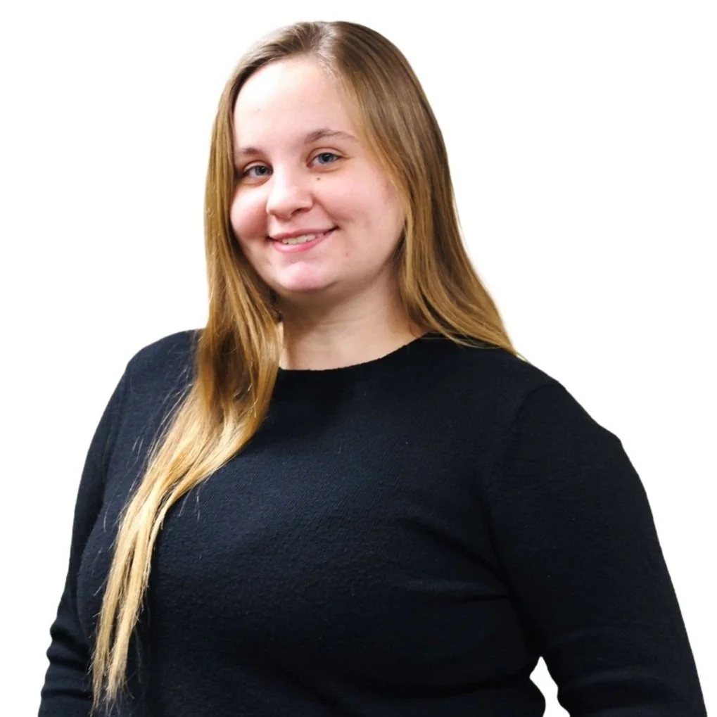 RIVET Coordinator, Kora Sloan, with long blonde hair wearing a black sweater smiles at the camera against a white background.