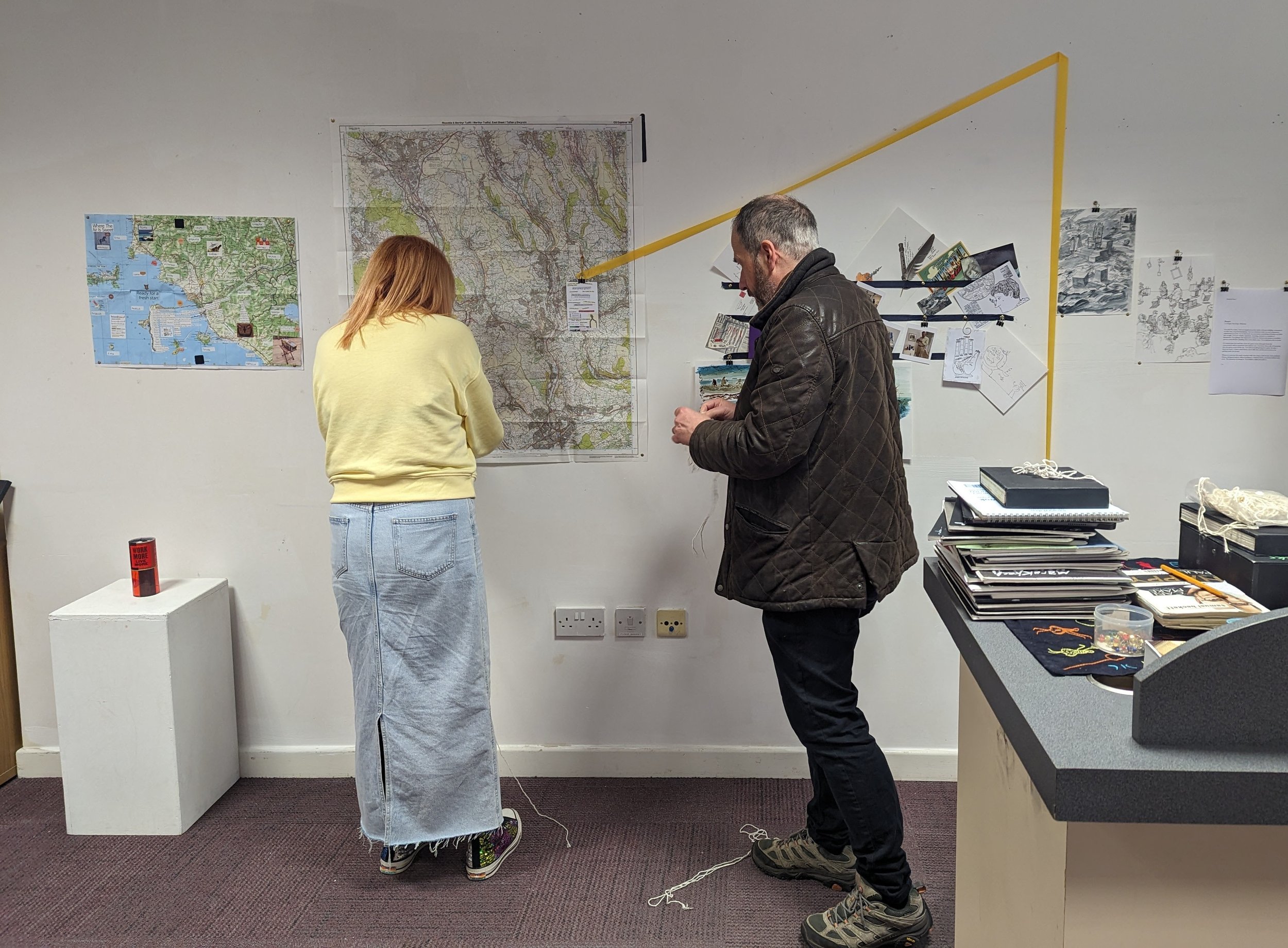 Kelly facilitating an interactive community arts and storytelling activity, helping participants contribute to a collaborative display exploring place, identity and personal experiences.