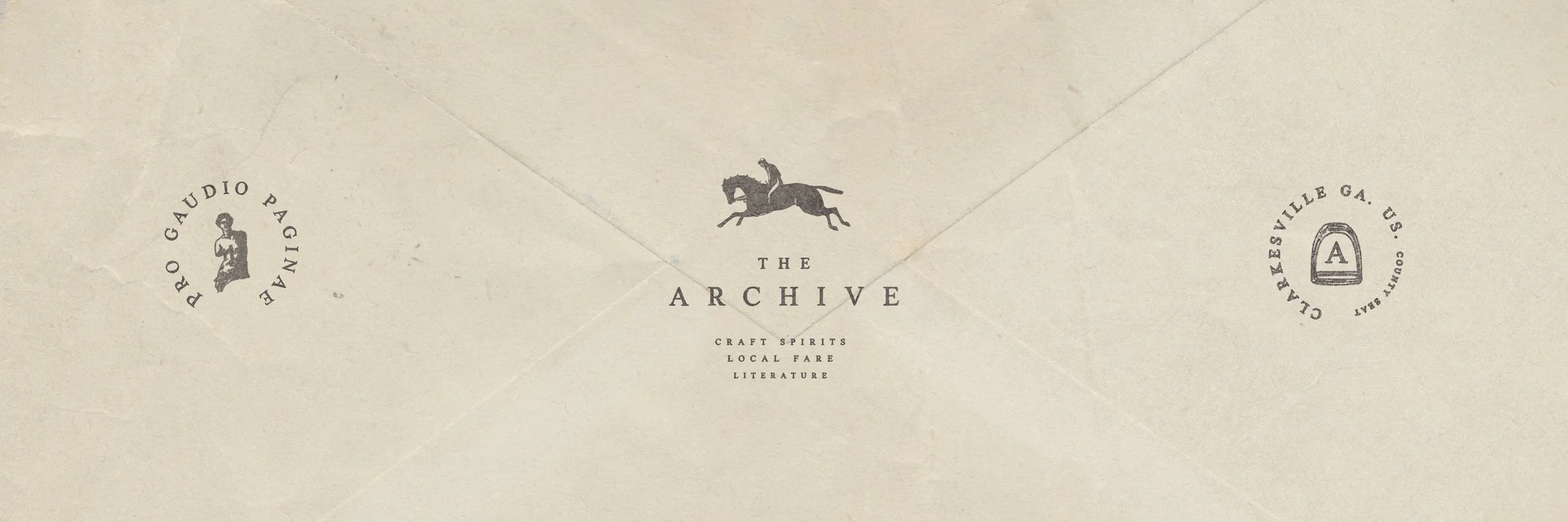 Envelope with a logo of a galloping horse and rider at center, and text around the edges reading 'Puro Gaudio Paginate' on the left and 'Cornerville Ga. U.S. Court Bear' on the right. The center text reads 'The Archive' with a subtitle 'Craft Spirits