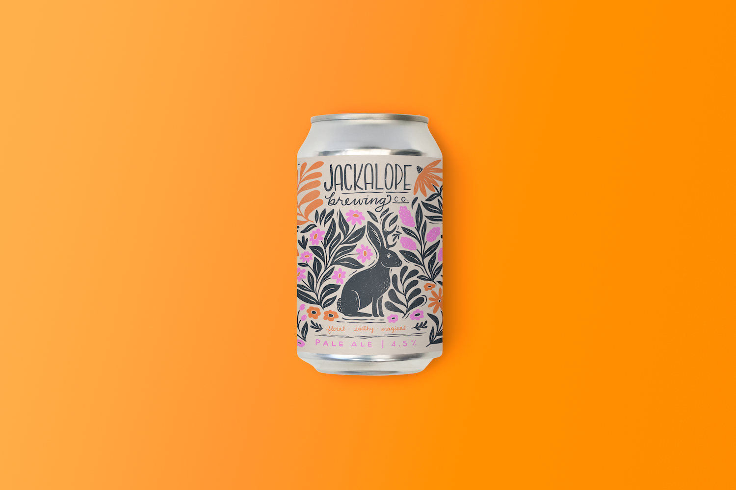 A can of Jackalope Brewing Co. pale ale with floral and rabbit illustrations on the label, set against a vibrant orange background.