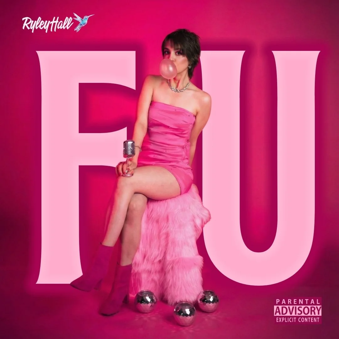 A young woman dressed in a pink strapless dress, sitting on a furry pink stool, with her legs crossed, blowing a bubblegum bubble. She has short dark hair, jewelry, and pink boots. The background is pink with large white letters spelling 'FUI' and a 'Parental Advisory' warning in the bottom right corner.