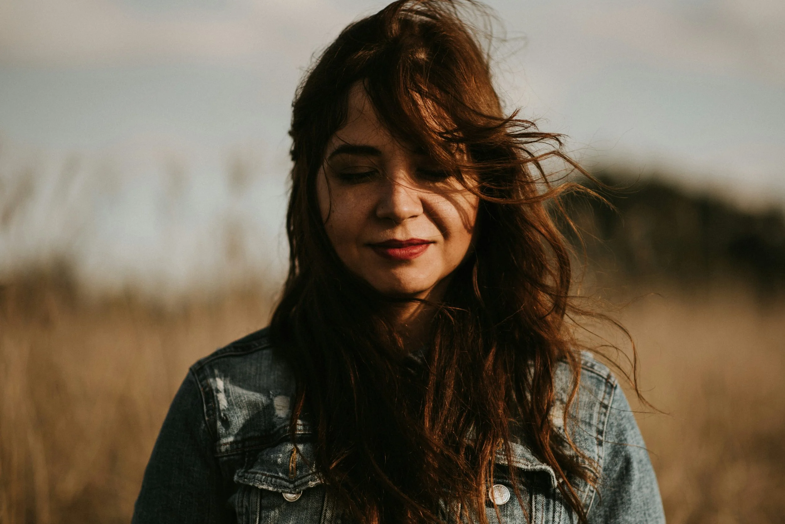 woman standing in a field with her eyes closed