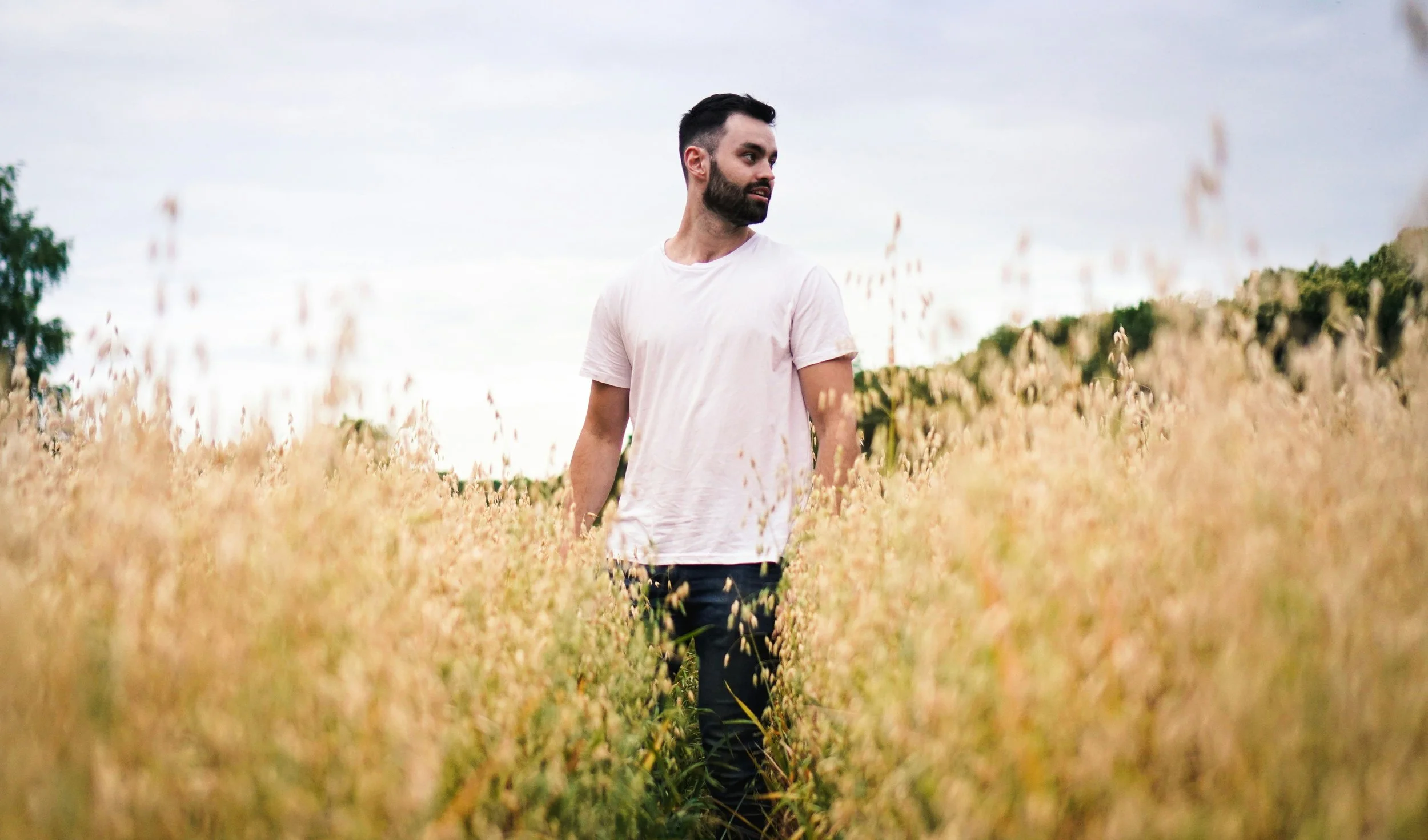 man in white crew neck t shirt standing at the fields