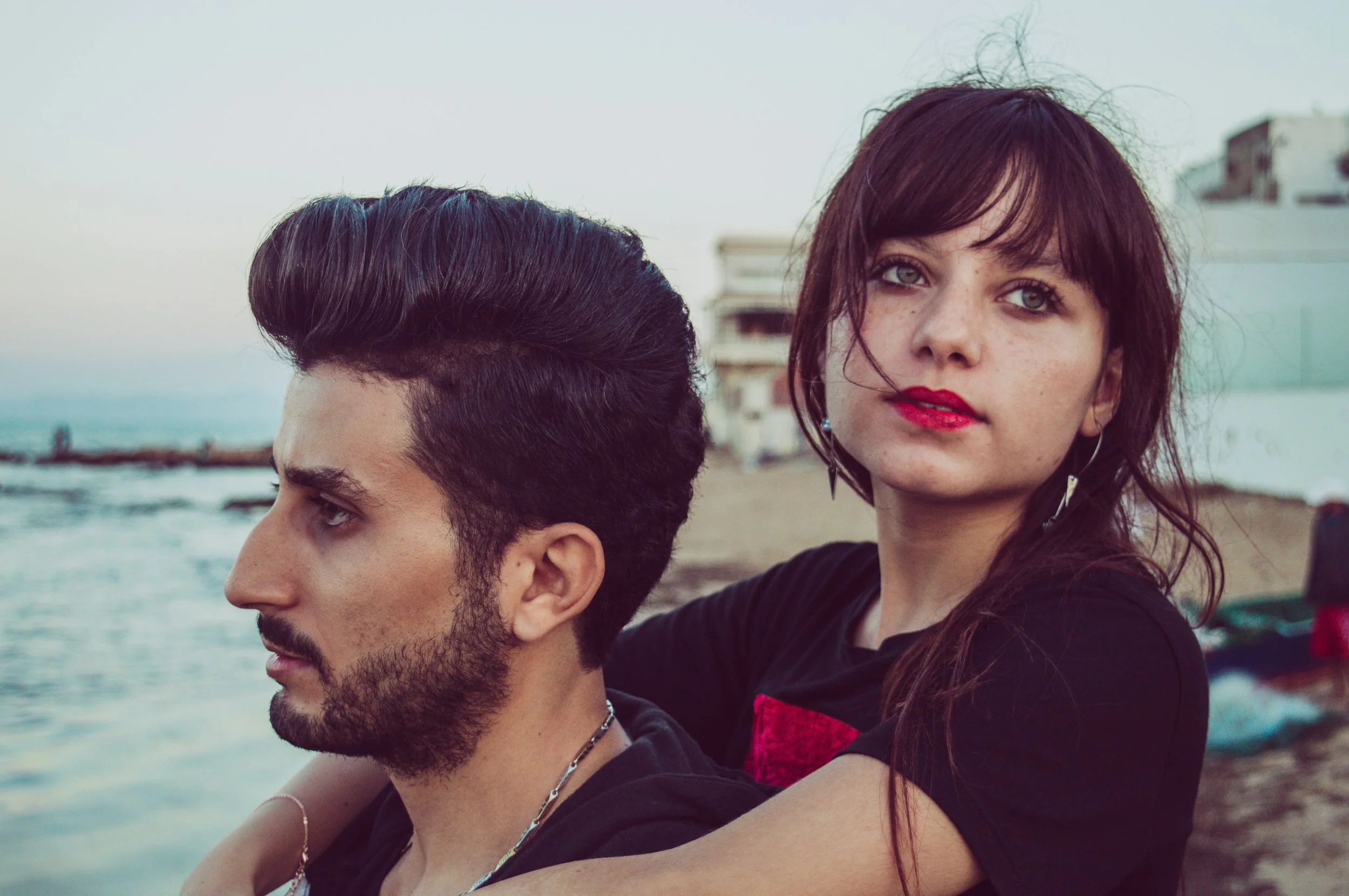 man and woman in black tops near the sea