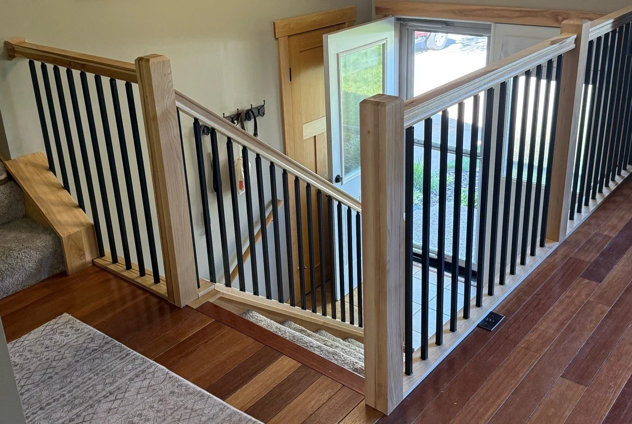 Custom hickory stair railing with black metal balusters installed in Fridley MN