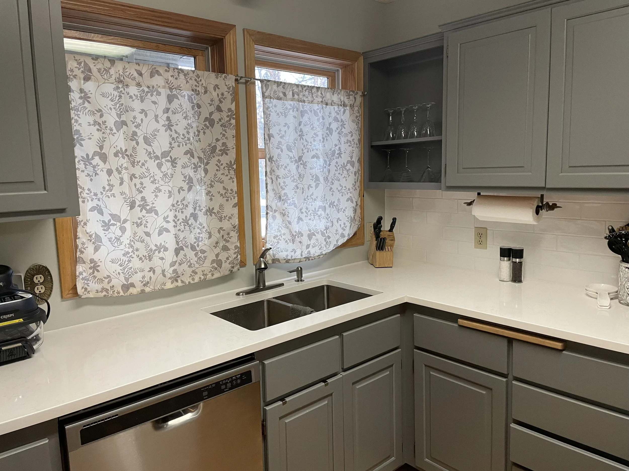 Kitchen sink and window area with quartz countertops and updated cabinets in Columbia Heights MN kitchen remodel.