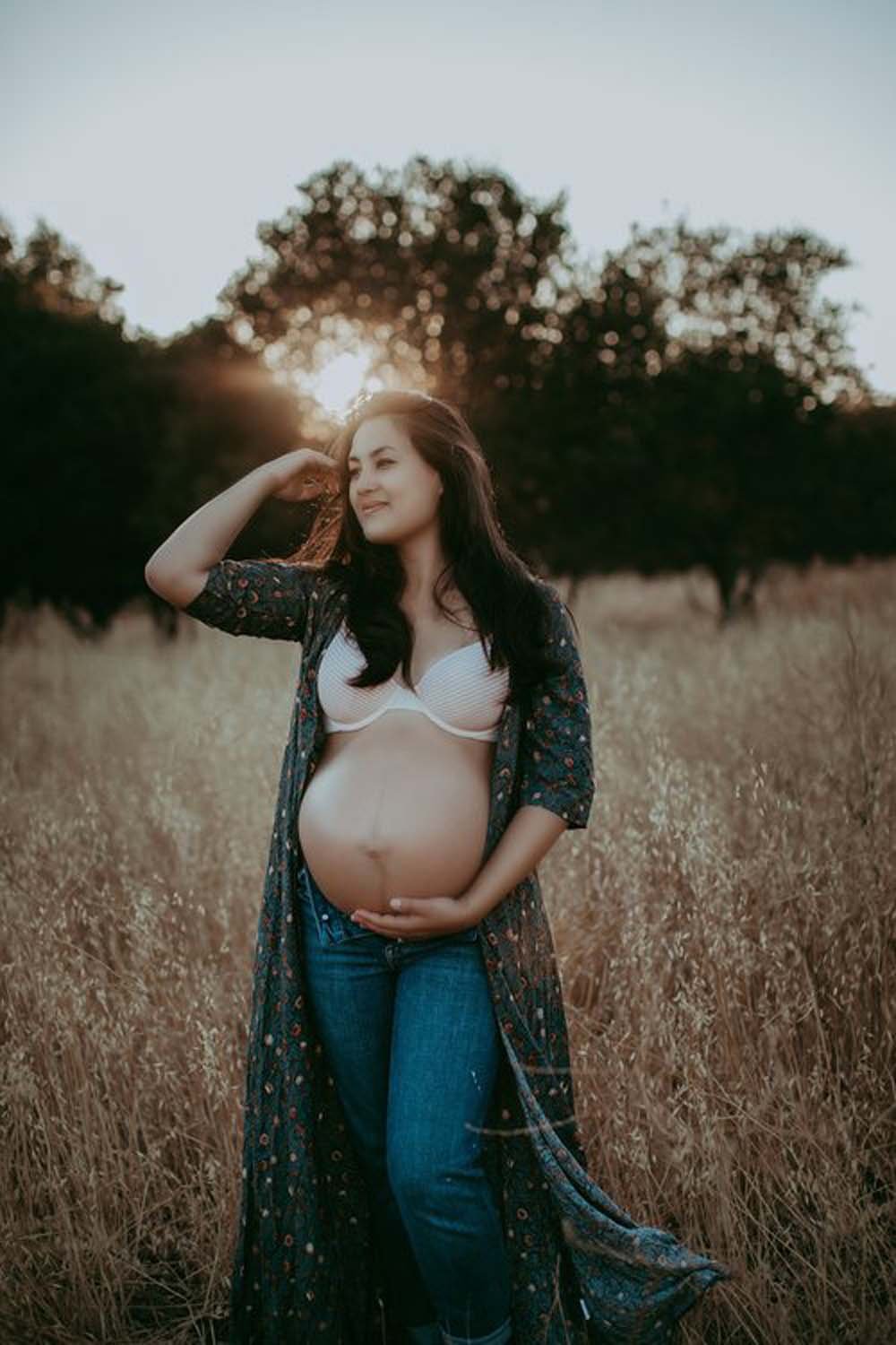 Mother to be outdoors holding belly maternity photoshoot Sacramento.jpg