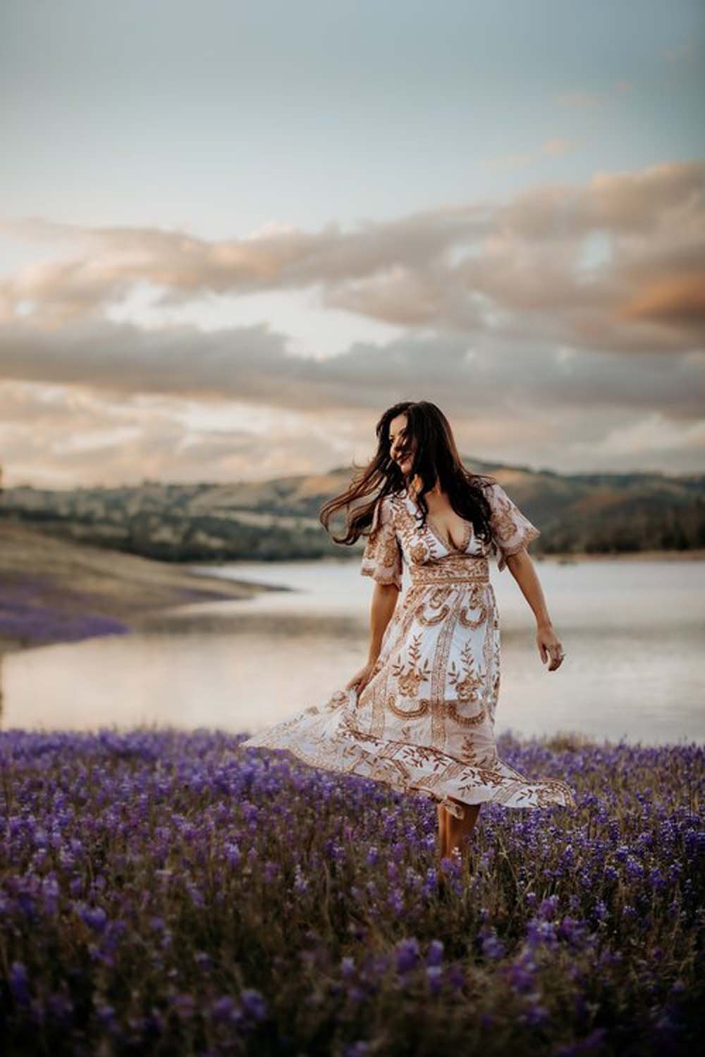 Woman in field of flowers by water Sacramento family photographer.jpg