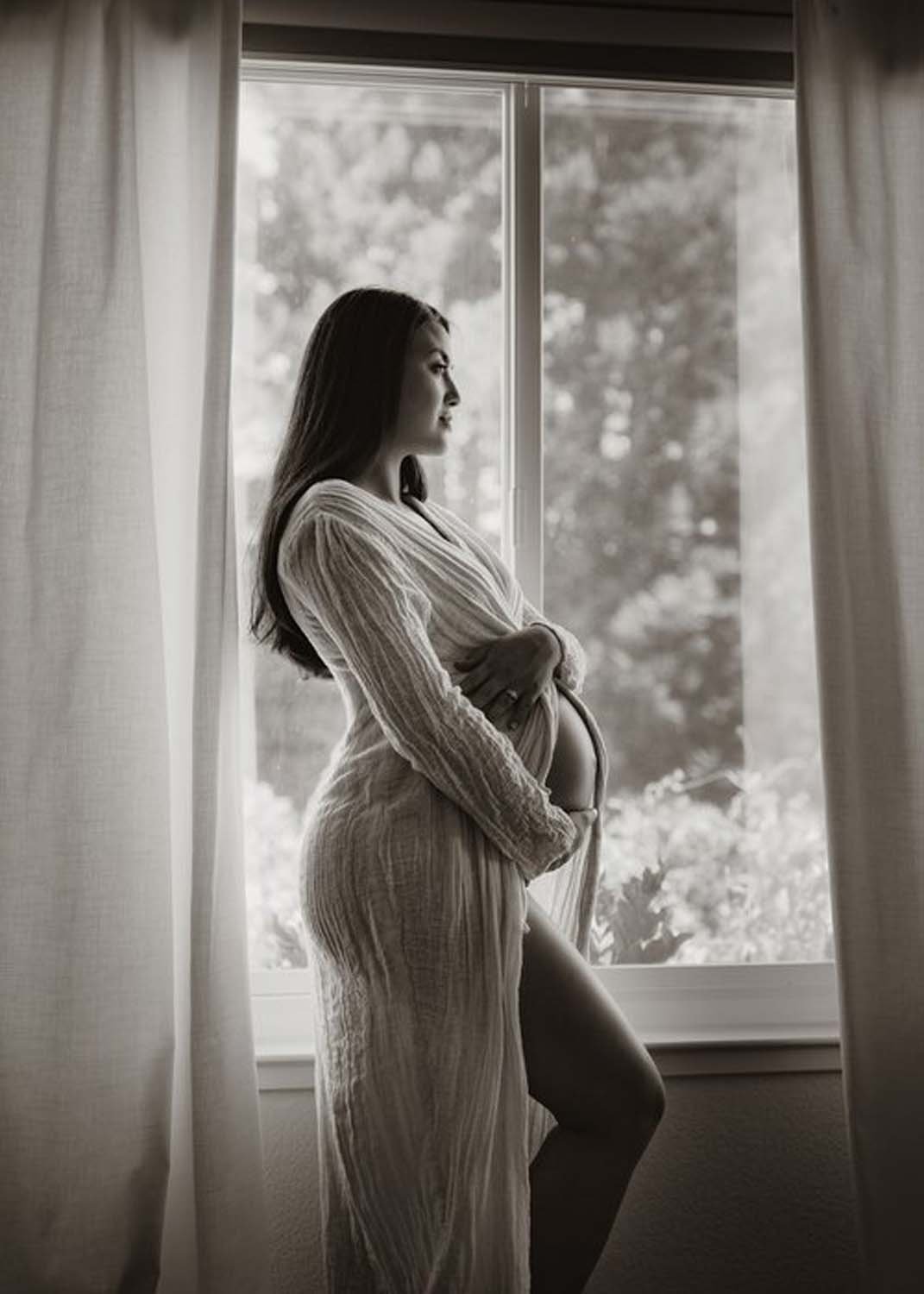 Black and white photo pregnant woman by window Sacramento baby photography .jpg