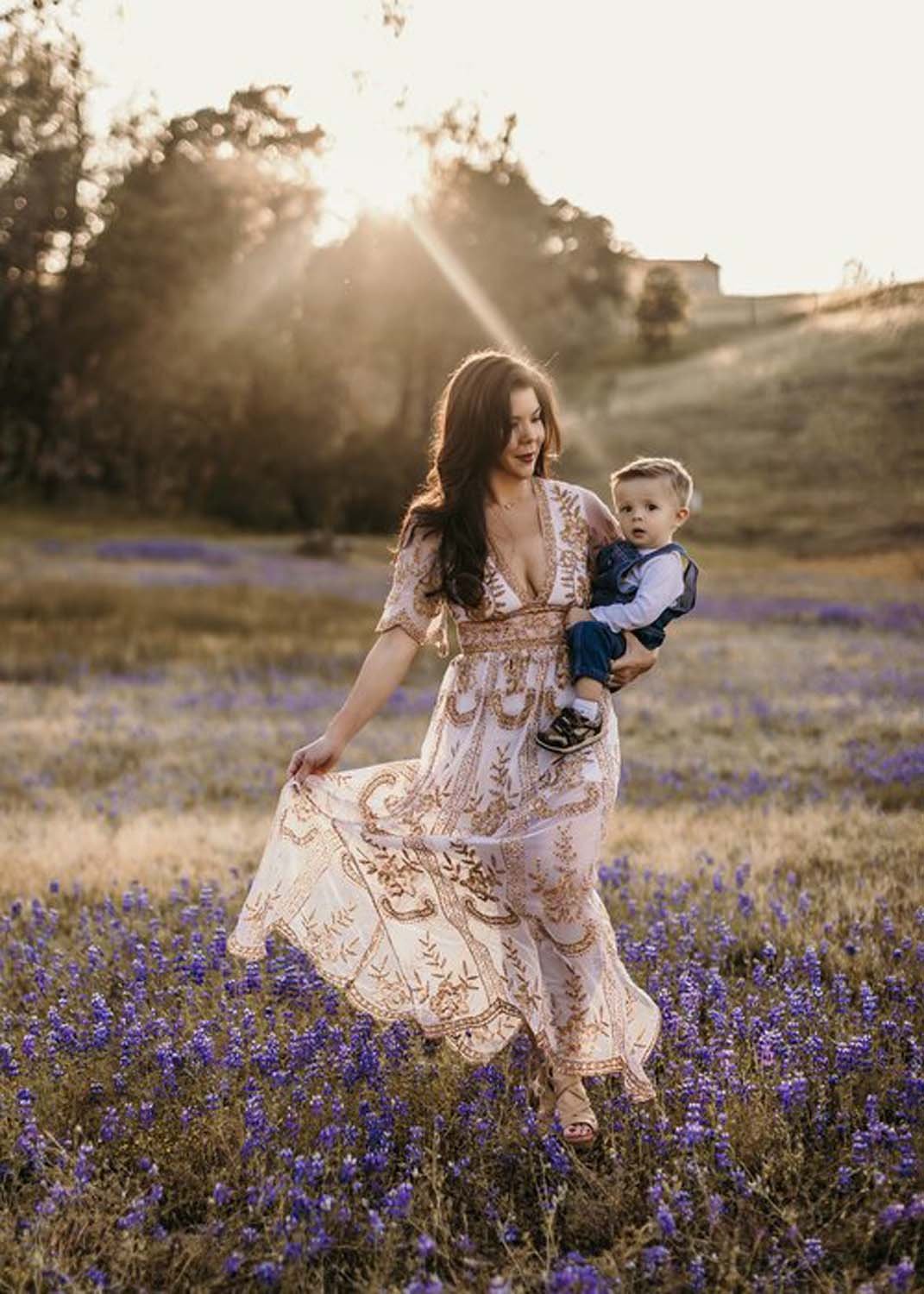 Mother carrying young boy in field of flowers Sacramento family photo studio.jpg