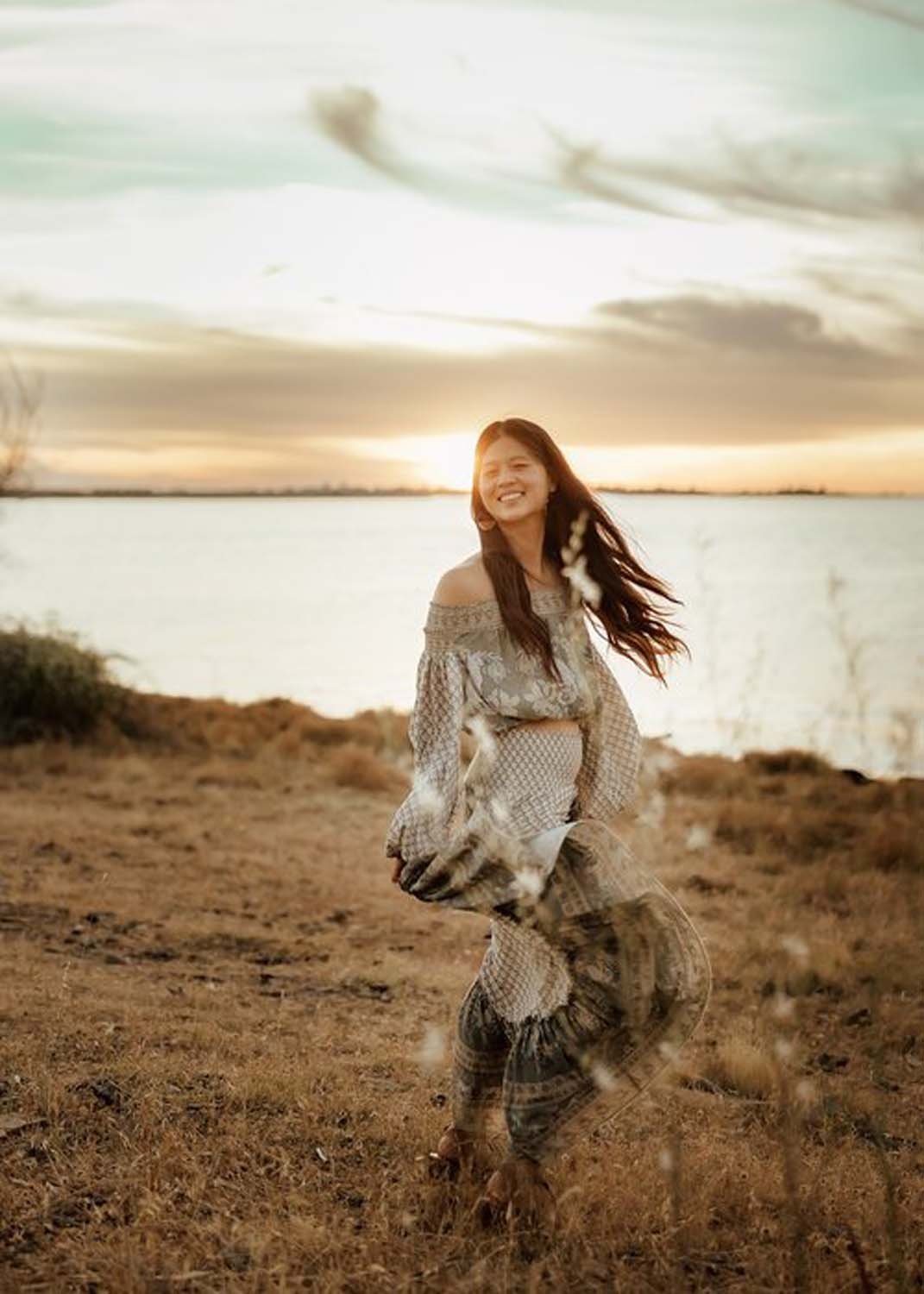 Woman smiling at sunset by water Sacramento family photos.jpg