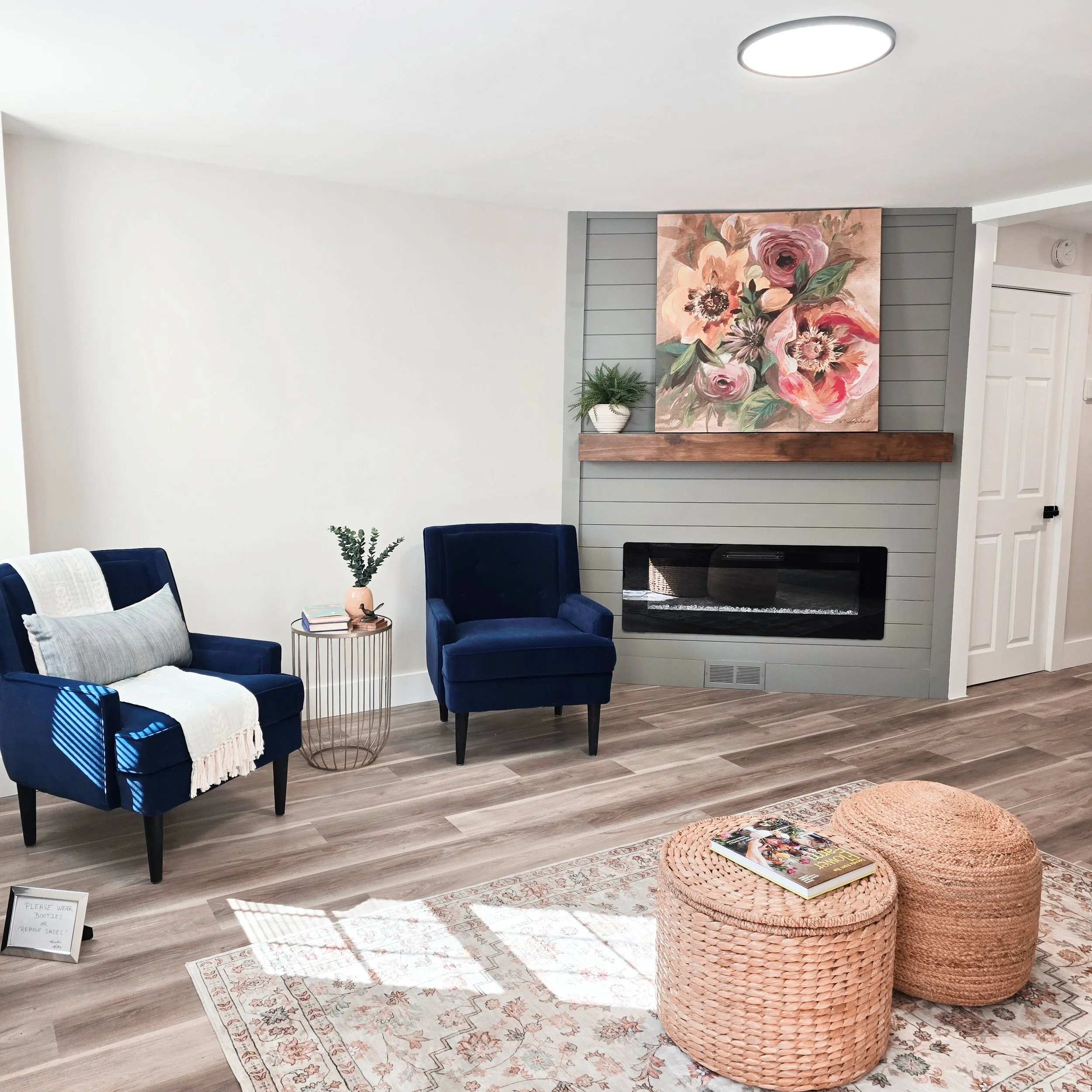 Professionally staged living room in a Columbia, PA home featuring comfortable furnishings, artwork above the fireplace, and warm neutral décor.
